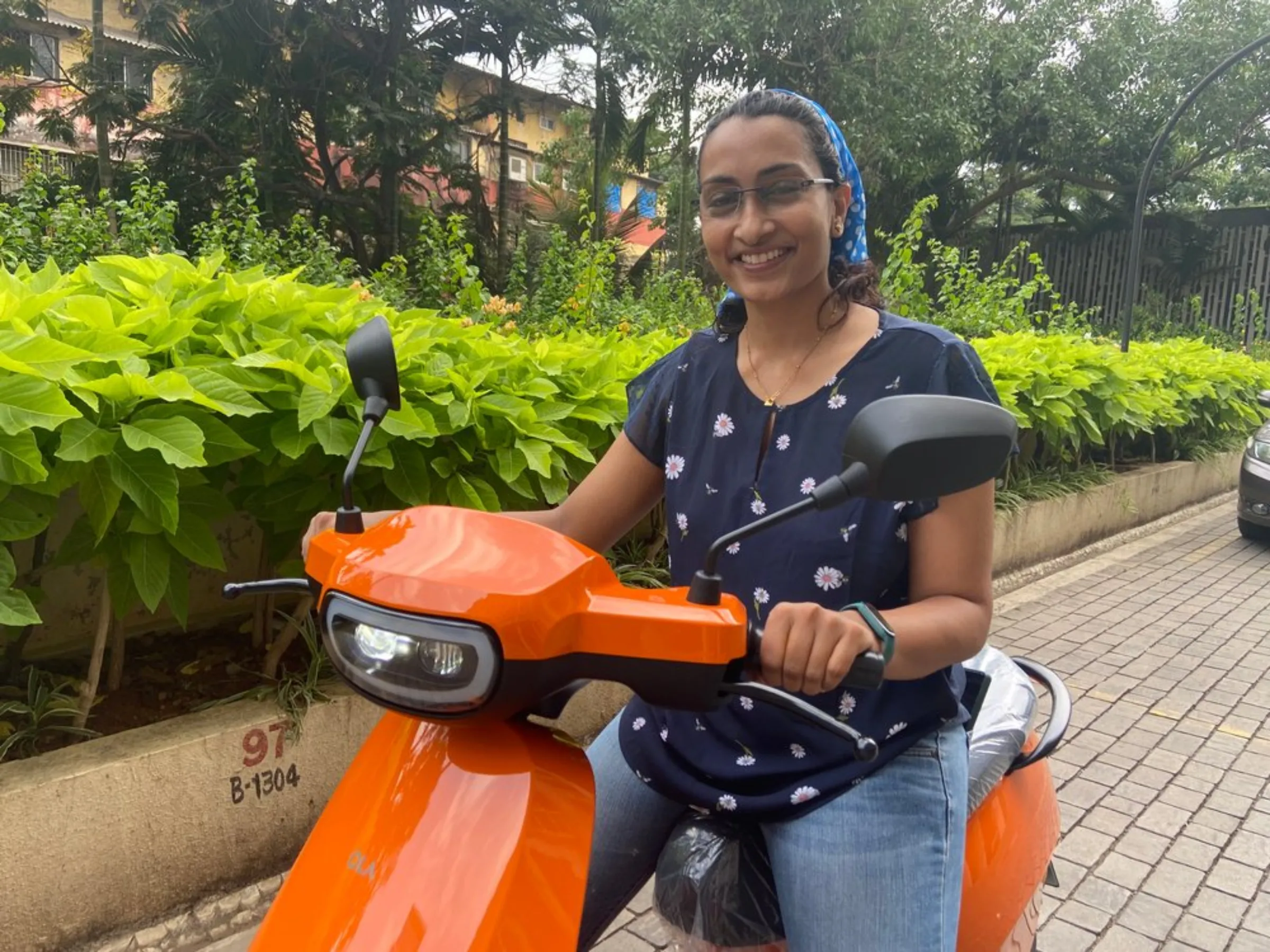 Rajni Arun Kumar poses with her new electric scooter at a residential complex in Mumbai, India, April 21, 2022