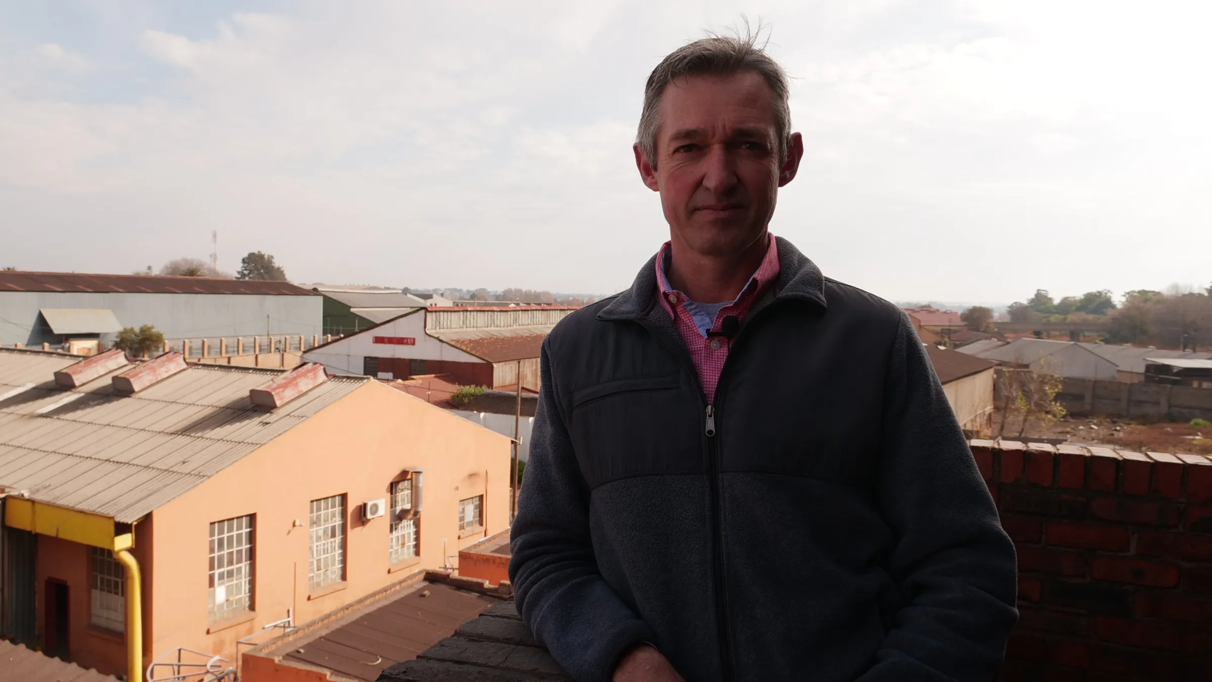 Darryl Phipps, the charcoal plant manager, poses for a photo on a landing overlooking the charcoal plant in Brakpan, Johannesburg, South Africa, June 8, 2025. Thomson Reuters Foundation/Kim Harrisberg