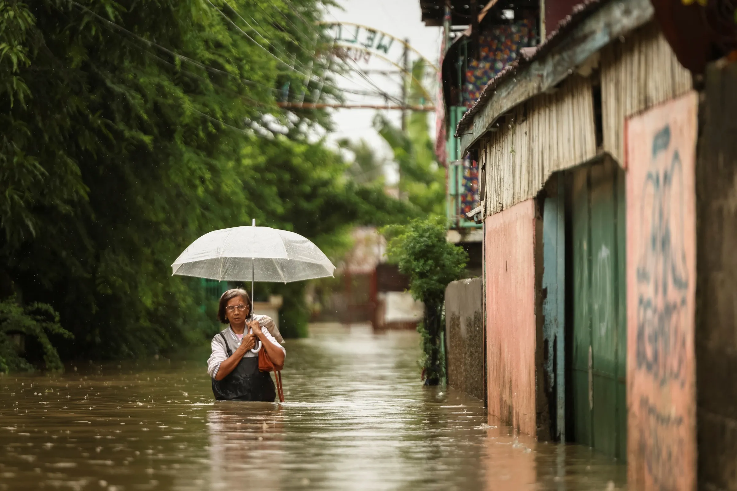 A woman wades through floodwaters as it rains during Tropical Storm Yagi, locally known as Enteng in Apalit, Pampanga, Philippines, September 5, 2024. REUTERS/Eloisa Lopez