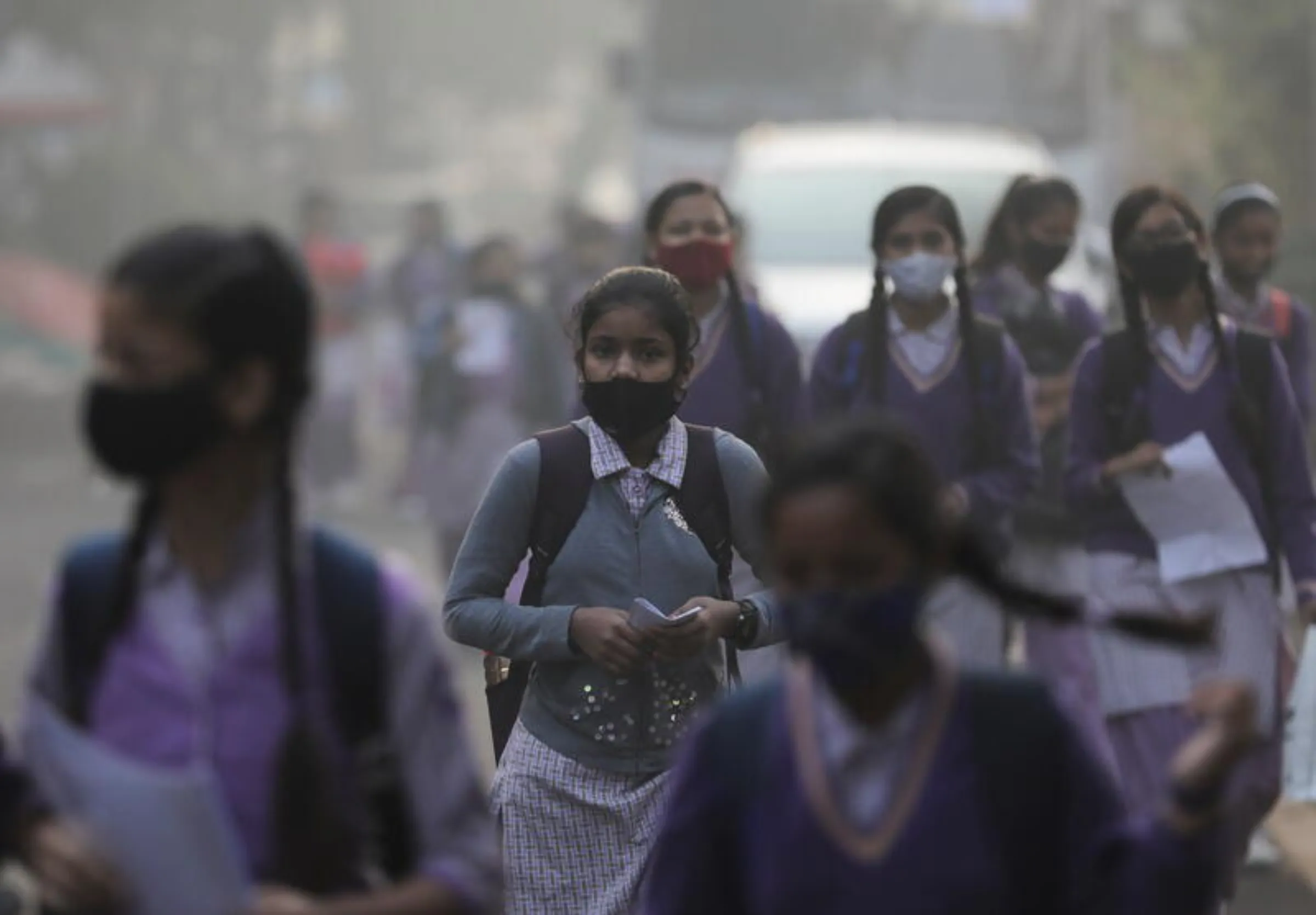 Girls walk towards a school reopened after being closed for nearly 15 days due to a spike in air pollution, on a smoggy morning in New Delhi, India, November 29, 2021. REUTERS/Anushree Fadnavis