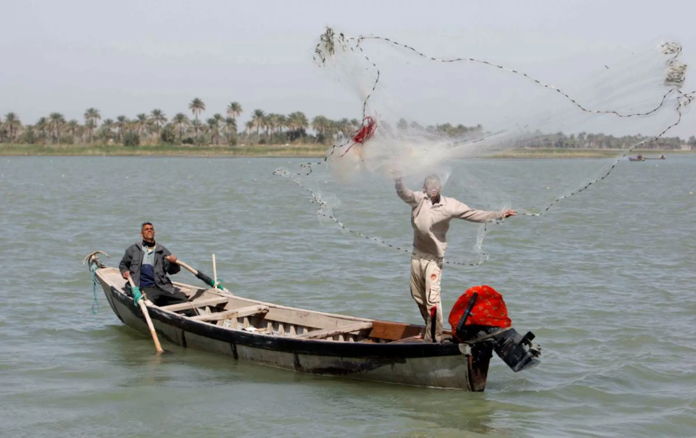 A fisherman casts his net into the waters of Shatt al-Arab near the southern city of Basra, 420 km (260 miles) southeast of Baghdad March 15, 2011