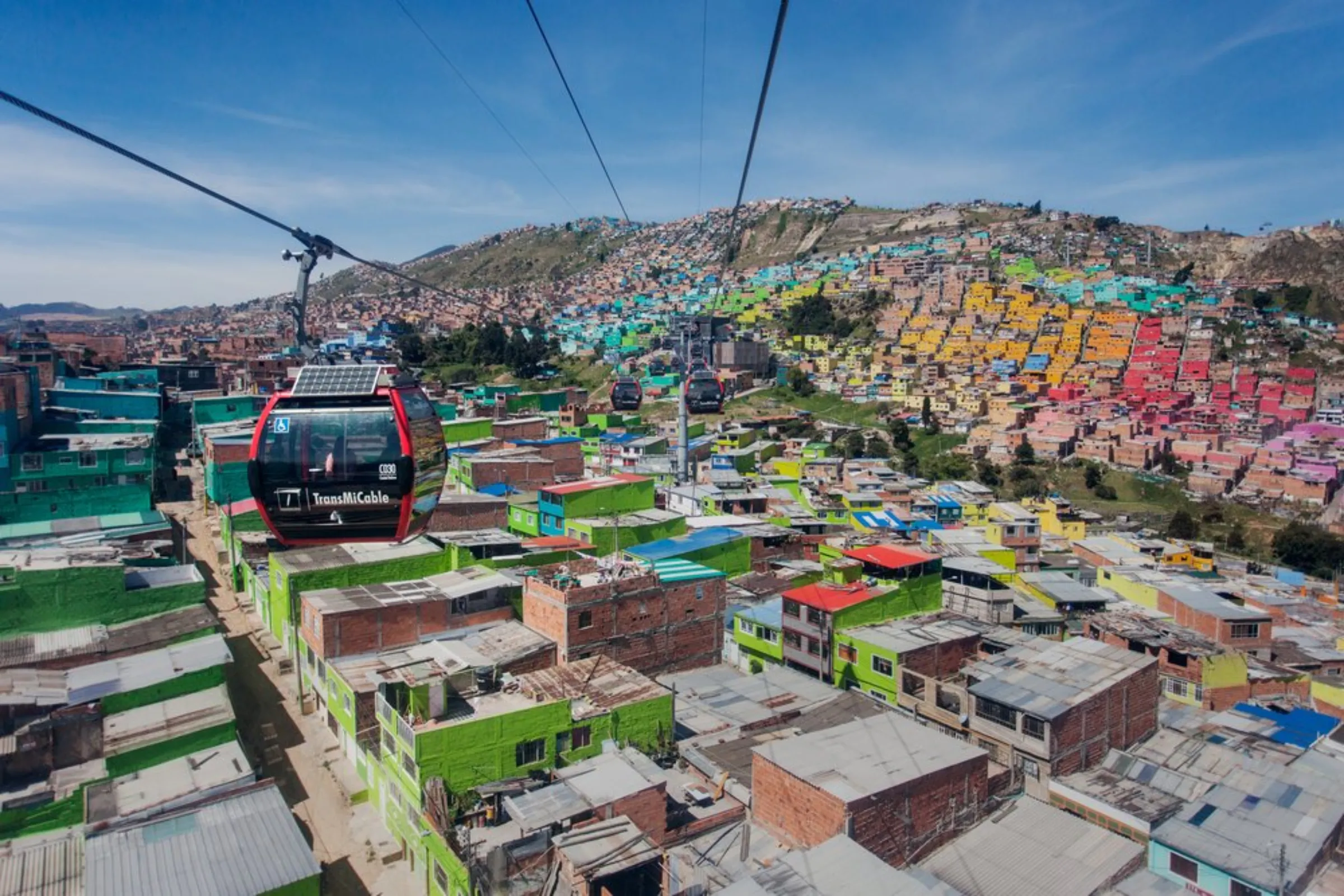 Cable cars travel over houses in Bogota, Colombia, April 20, 2021. The gondola network helps connect residents in steep hillside districts with the city’s northwest areas