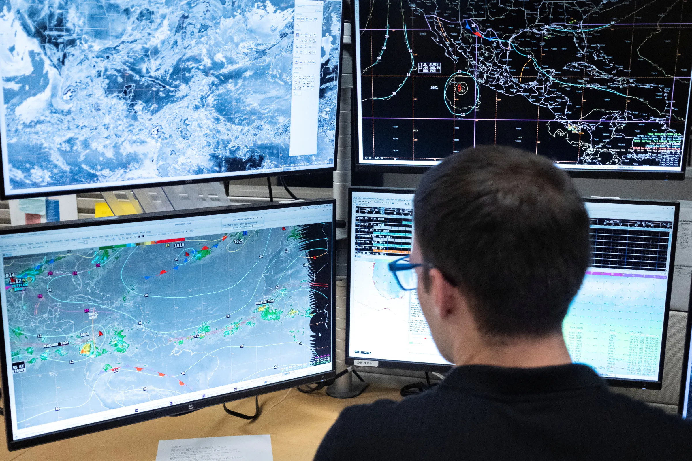 Tropical analysis meteorologist Aidan Mahoney looks at monitors as he works at his station at the National Oceanic and Atmospheric Administration's (NOAA) National Hurricane Center in Miami, Florida, U.S. May 30, 2025. REUTERS/Marco Bello