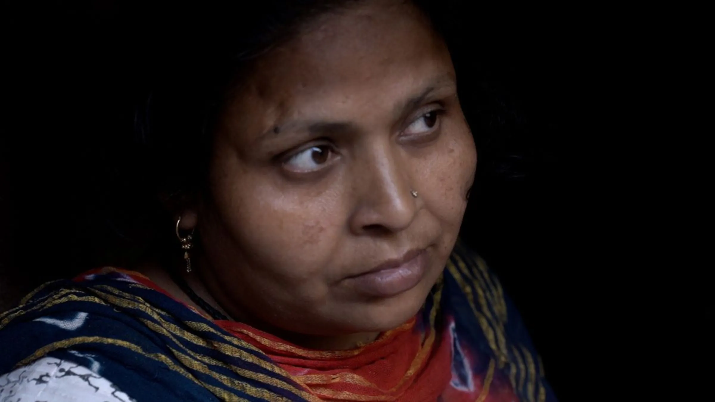 A domestic worker sits outside her house in New Delhi, India, in this video still filmed February 6, 2023. Thomson Reuters Foundation/Jacob Templin