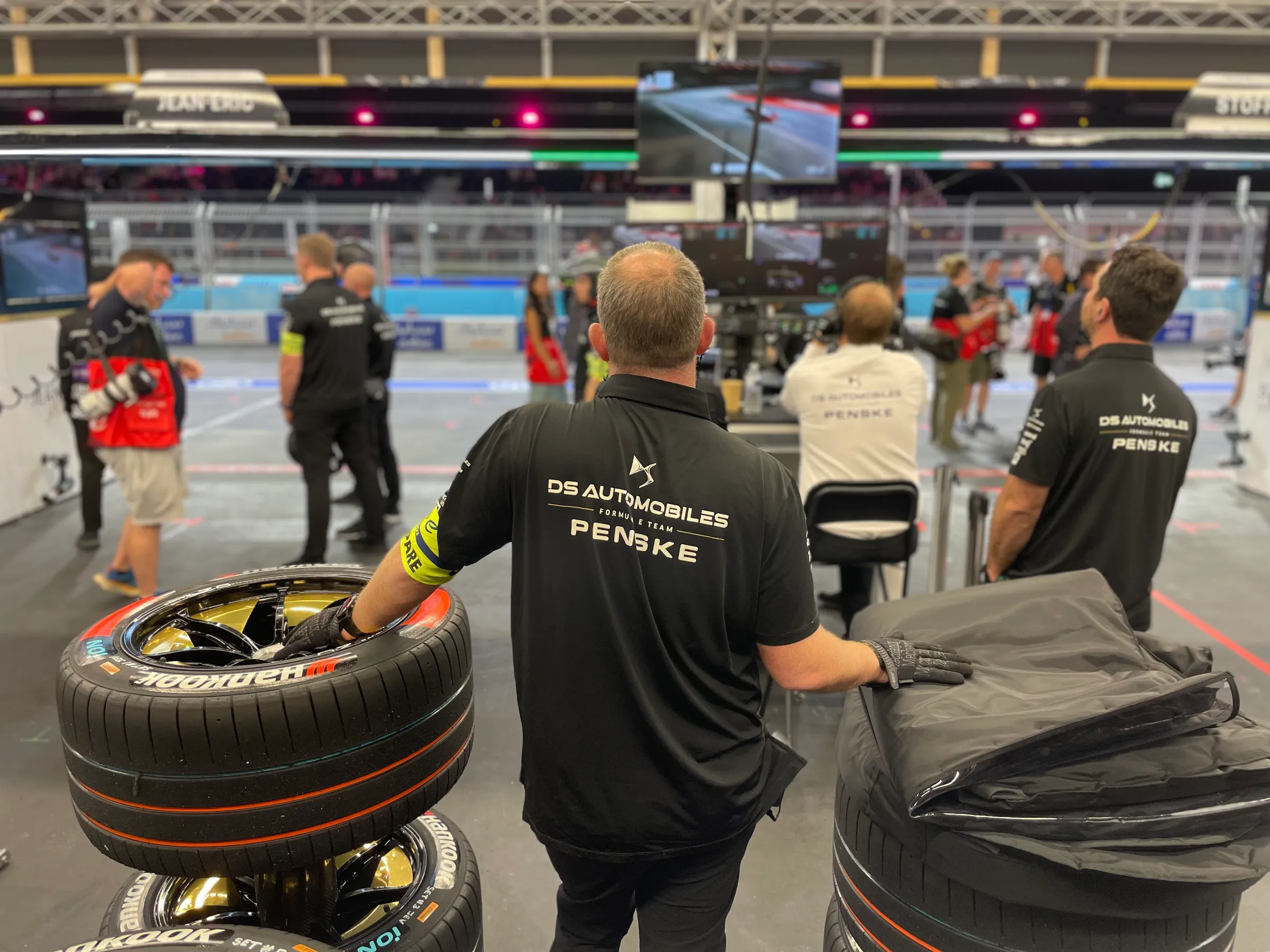 A member of the DS Penske pit crew stands with his hands resting on piles of tyres in the pitlane garage during the round 15 qualifying race of the Formula E world championship at the ExCeL Centre in London, July 20, 2024.