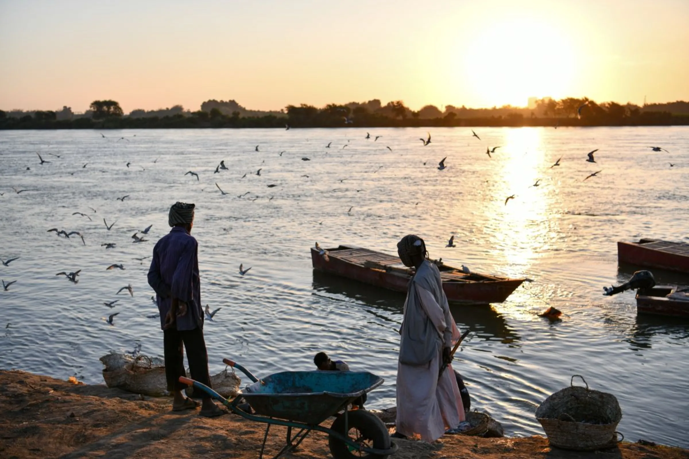 Sudanese traders await the arrival of fishermen with the day’s catches by the Nile River bank in Omdurman, Sudan, February 11, 2023. Thomson Reuters Foundation/Ela Yokes