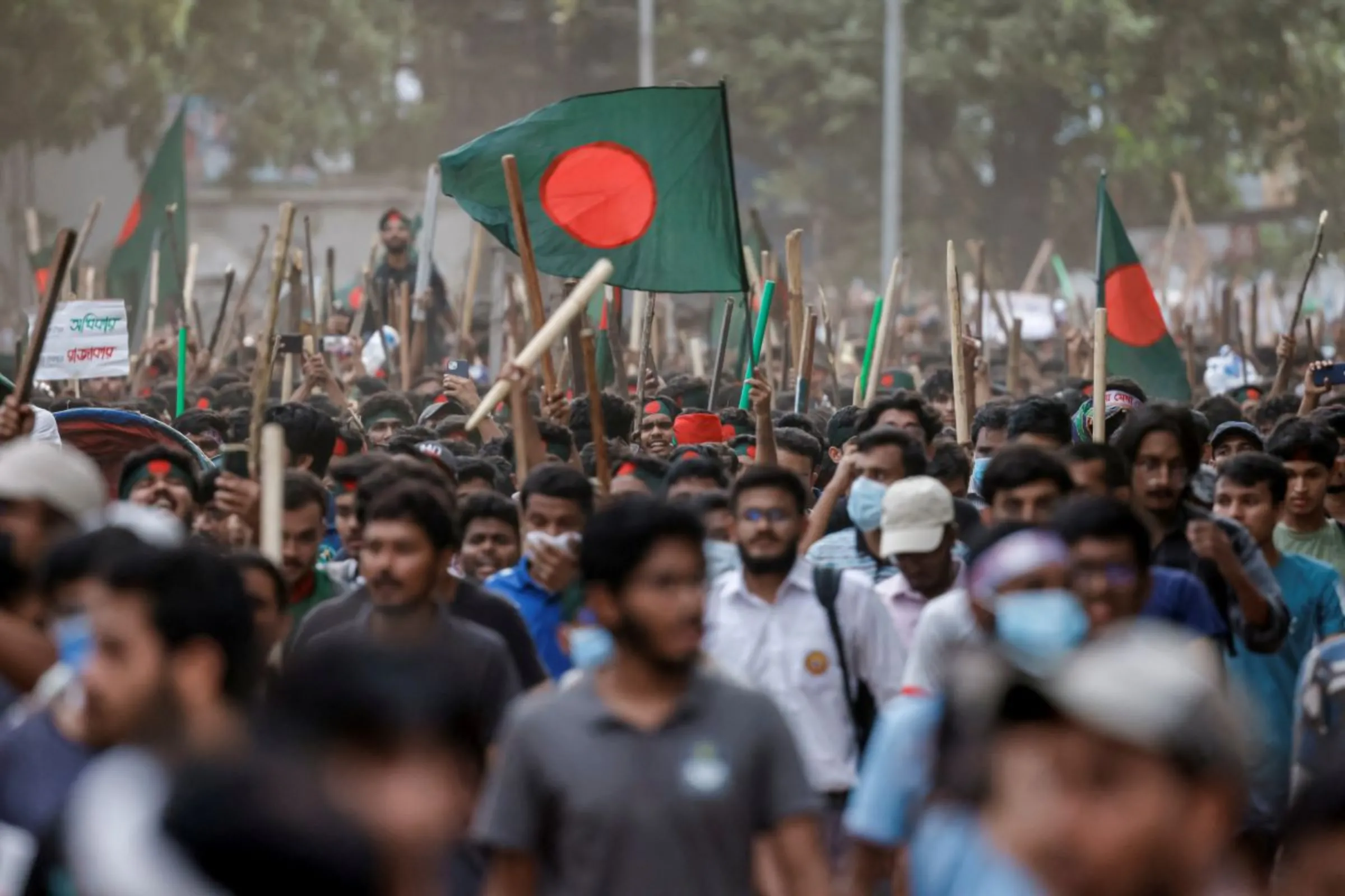Anti-quota protesters march with Bangladeshi flags and sticks as they engage in a clash with Bangladesh Chhatra League, the student wing of the ruling party Bangladesh Awami League, at the University of Dhaka, in Dhaka, Bangladesh, July 16, 2024. REUTERS/Mohammad Ponir Hossain
