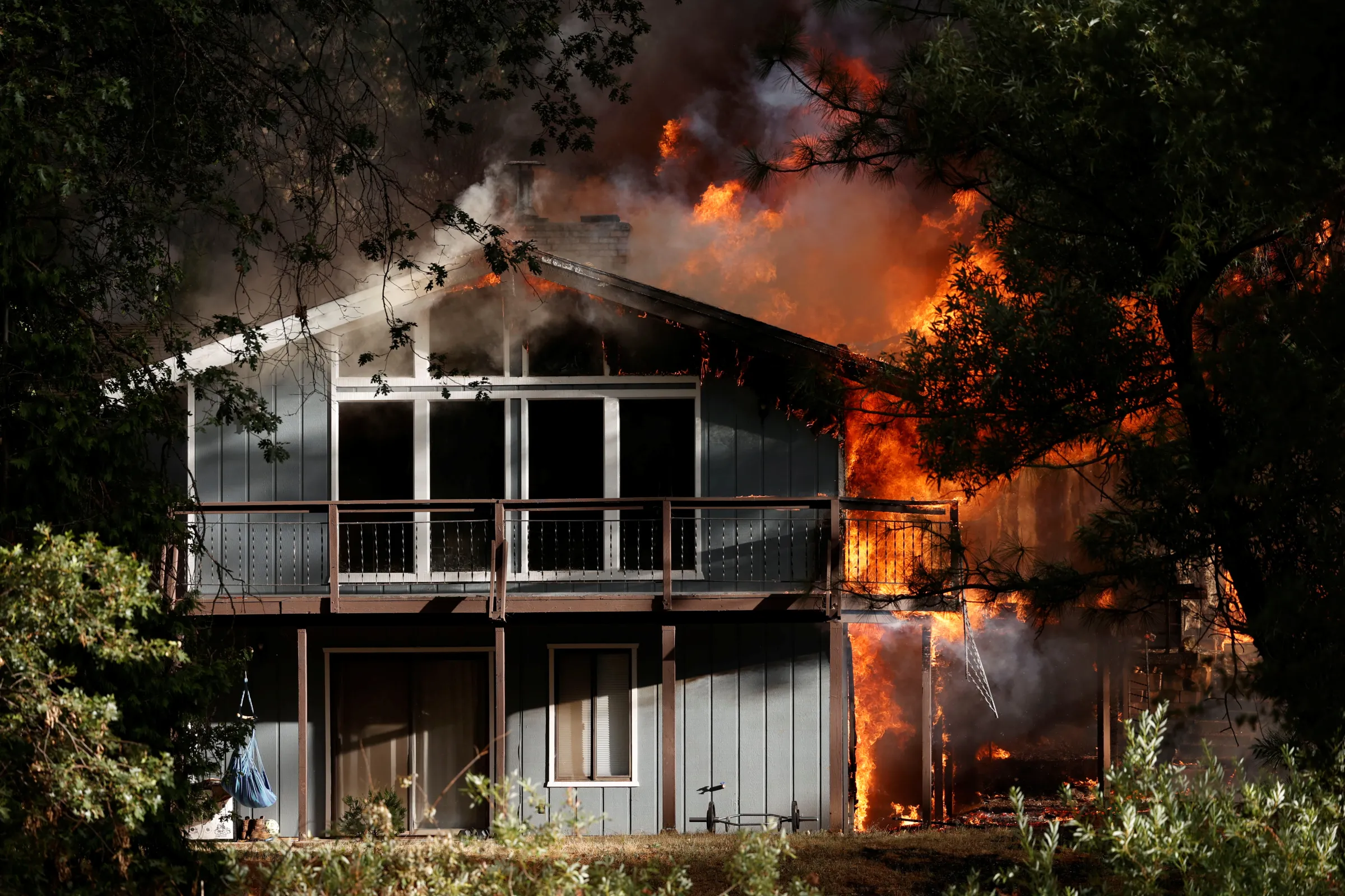 A house is burning surrounded by trees