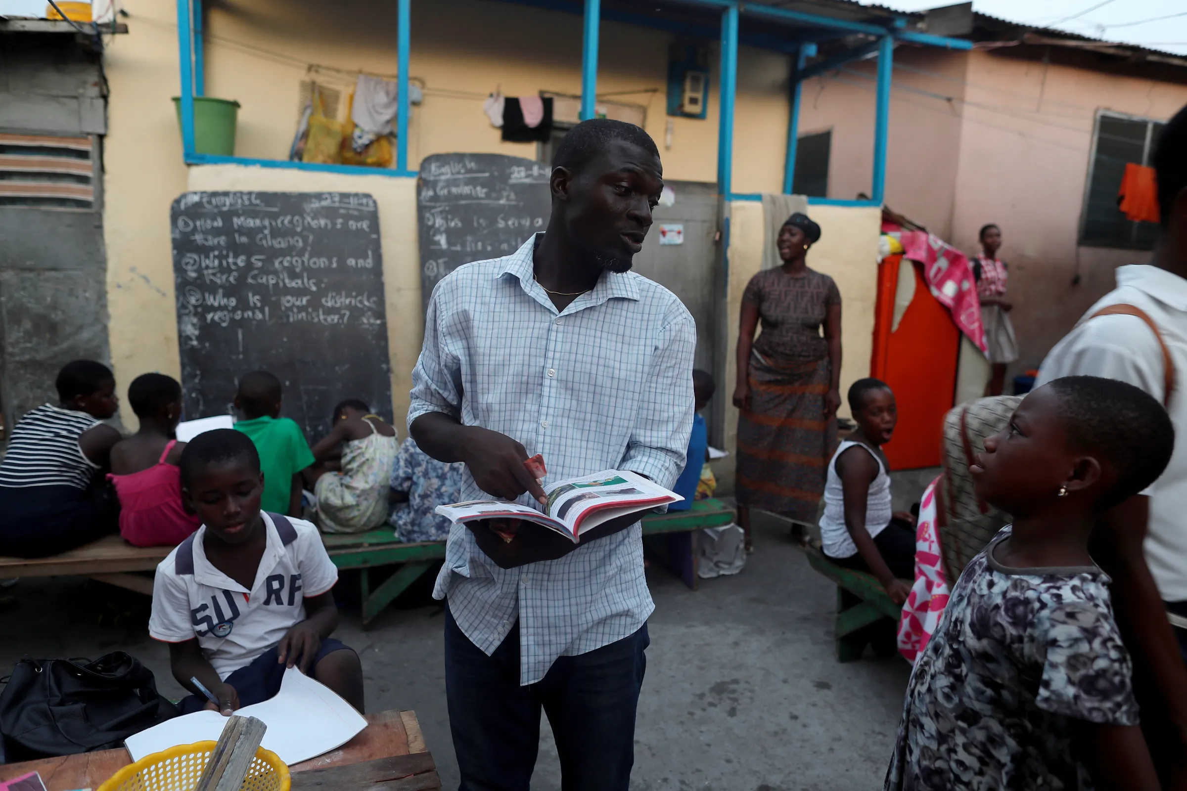 A teacher talks to a boy before he starts the evening class in Jamestown, Accra, Ghana November 28, 2018. REUTERS/Zohra Bensemra