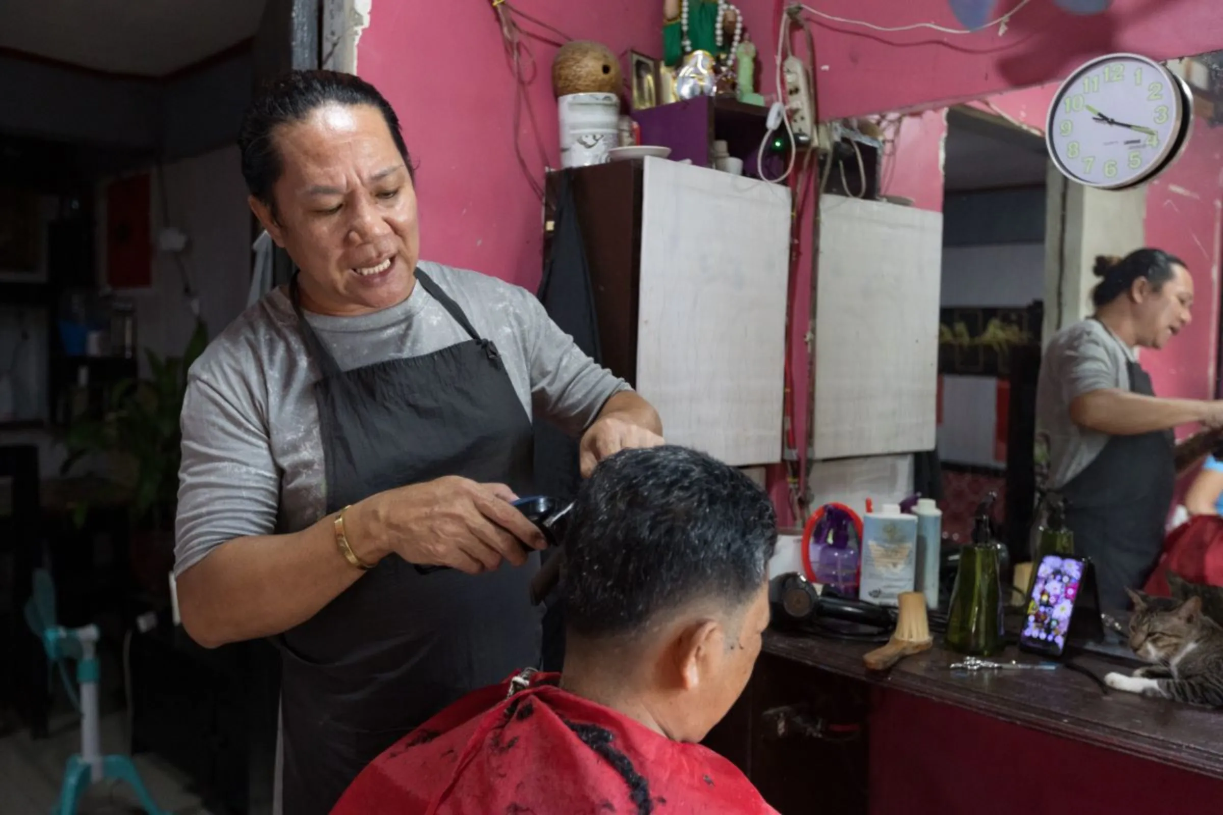 Arthur Golong services neighbours and clients in the makeshift salon she constructed inside her home. Golong is among the recipients of a housing programme for survivors of Super Typhoon Haiyan in Tacloban City, Philippines.  October 8, 2023. Thomson Reuters Foundation/Kathleen Lei Limayo