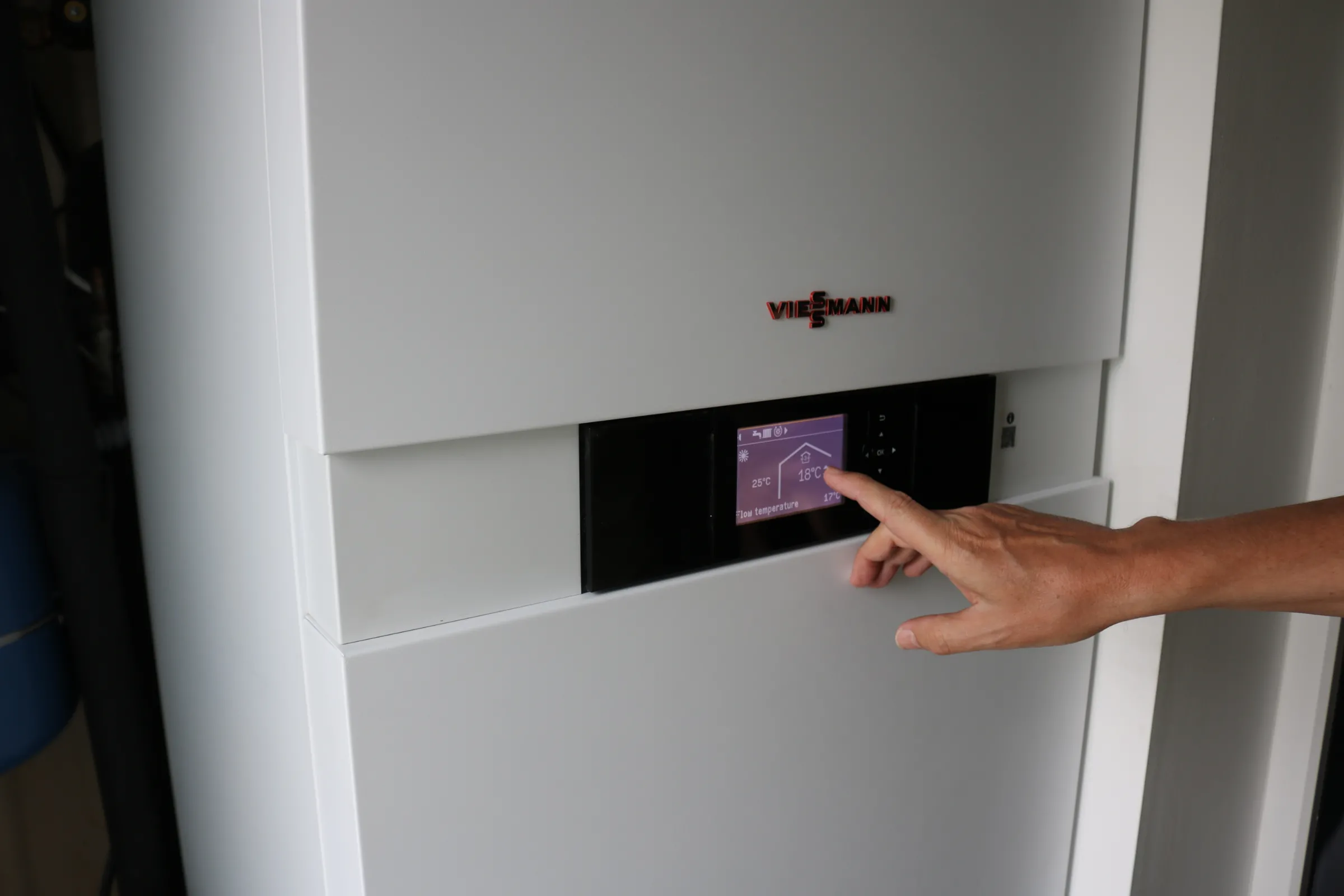 A man points at a smart meter on a heat pump