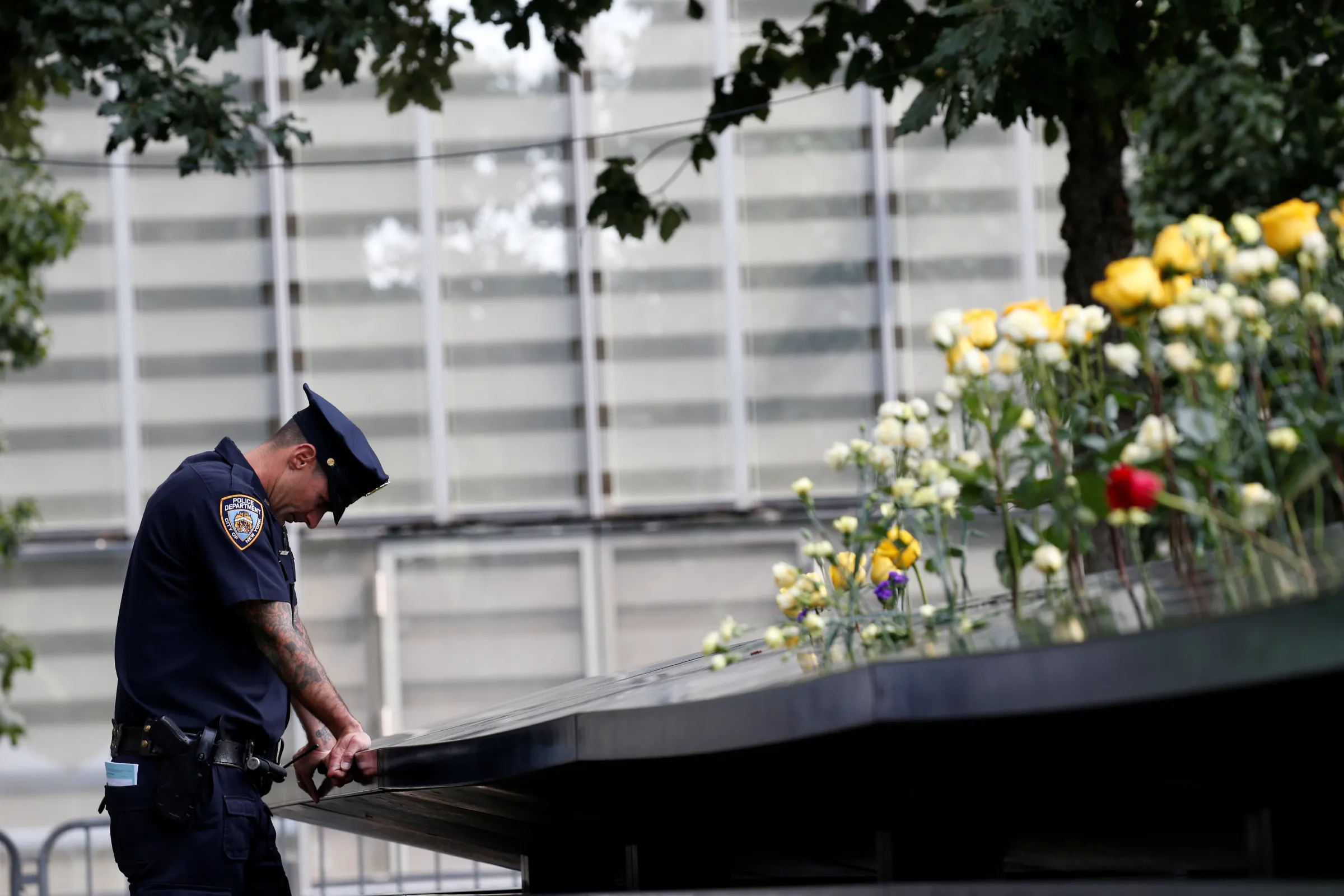 A NYPD officer pauses at the edge of the south reflecting pool at the National 9/11 Memorial and Museum during ceremonies marking the 16th anniversary of the attacks in New York, U.S., September 11, 2017. REUTERS/Brendan McDermid
