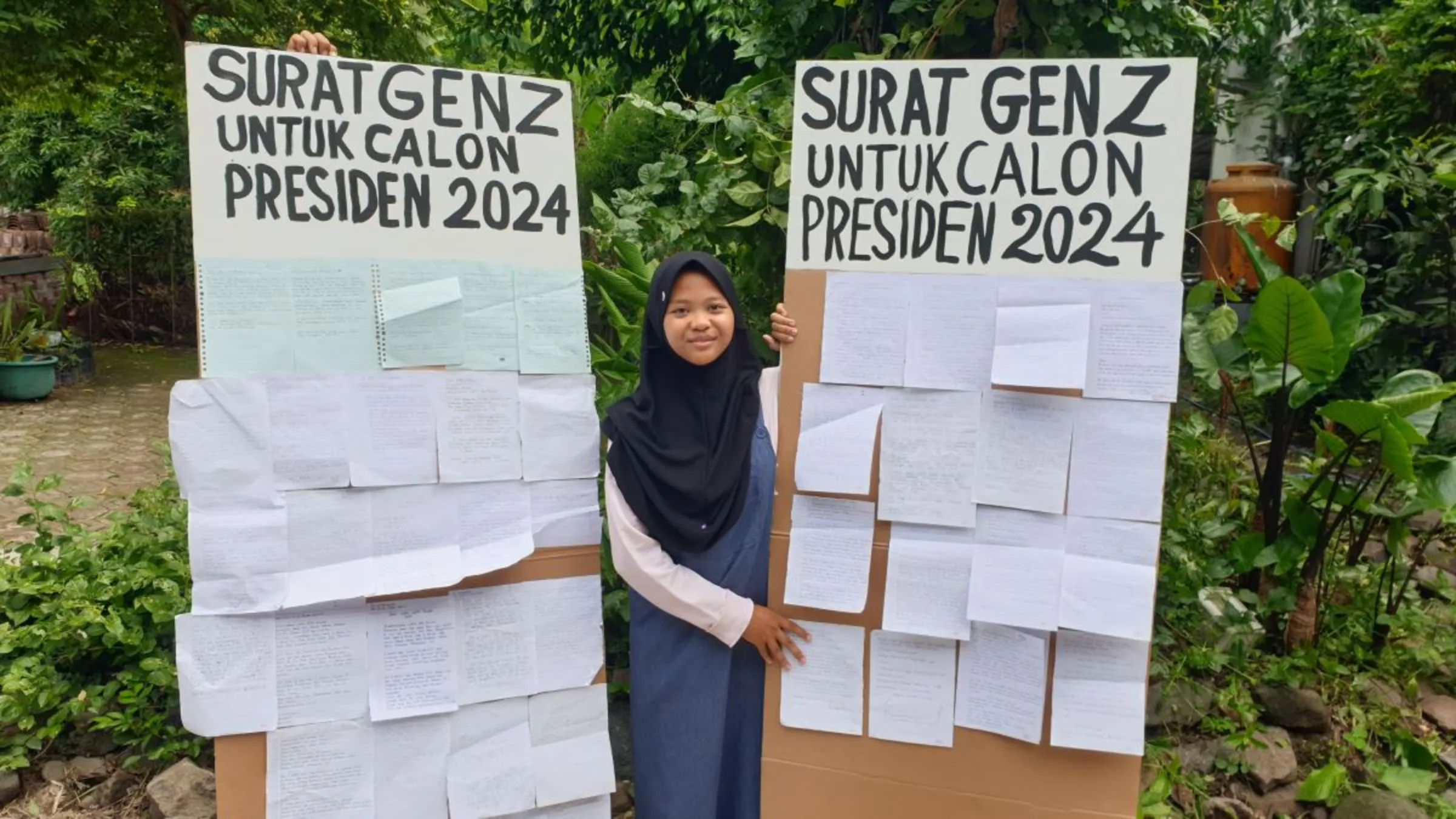 Aeshnina Azzahra Aqilani poses with the climate action letters she collected from youths, January 13, 2024. Thomson Reuters Foundation/Asad Asnawi