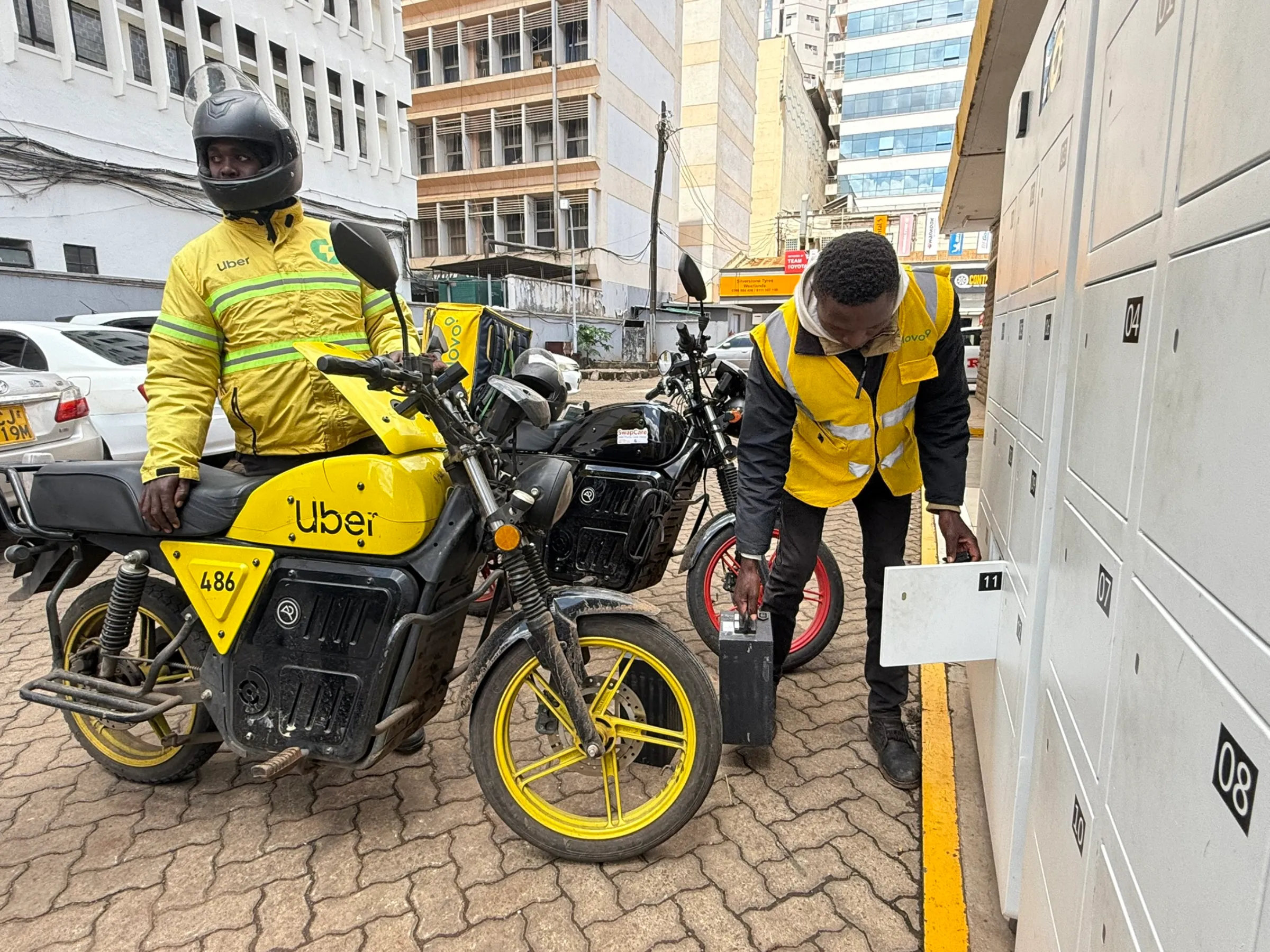 Motorbike taxi drivers swap their used batteries for charged ones at a battery switching station operated by Kenyan e-mobility start-up ARC Ride in Nairobi, Kenya on Nov. 8, 2024. Thomson Reuters Foundation/Nita Bhalla