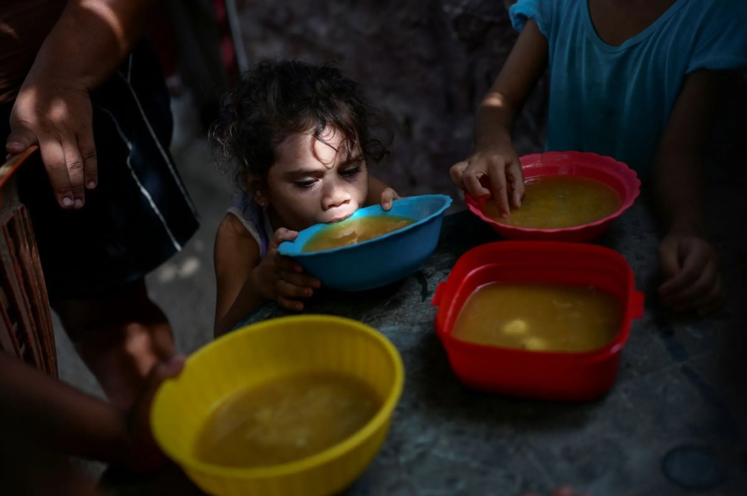 A child drinks soup from a bowl in Venezuela June 12, 2024. REUTERS/Gaby Oraa