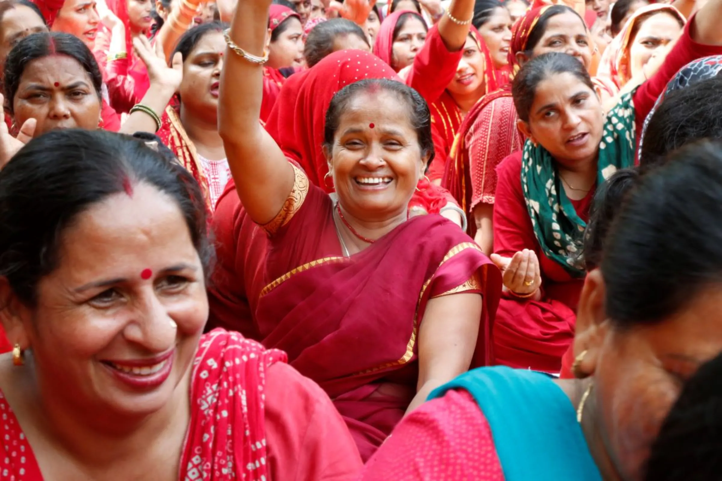 Community health workers punch the air with their fists during a protest in Gurugram, India, September 19, 2023