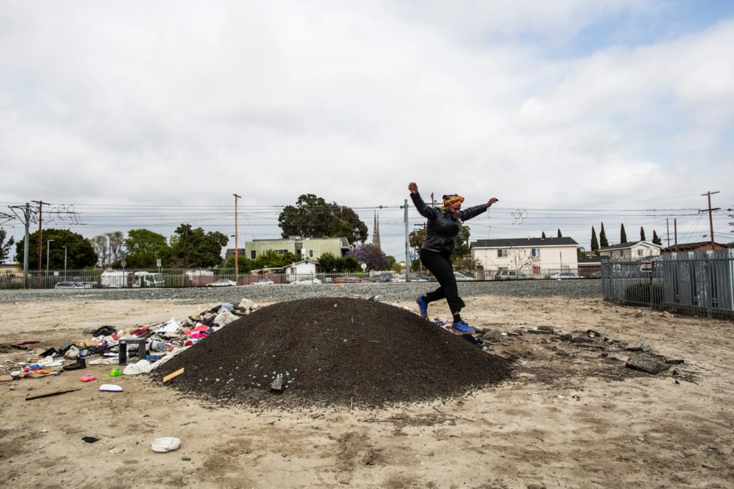 Community activist Jaquelyn Badejo runs down a mound in a lot in her Watts neighbourhood in southern Los Angeles, California, May 17, 2021