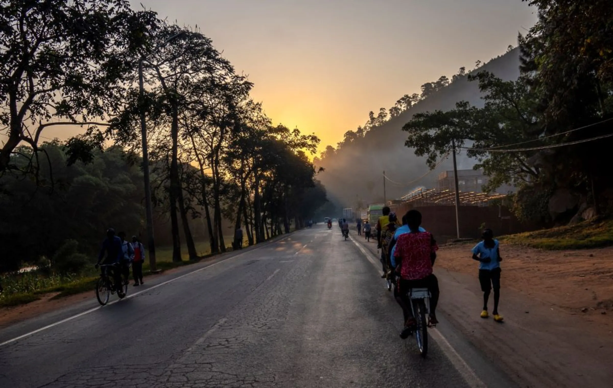 Residents cycle along a road at dawn on the outskirts of Kigali, Rwanda June 15, 2022. REUTERS/Jean Bizimana