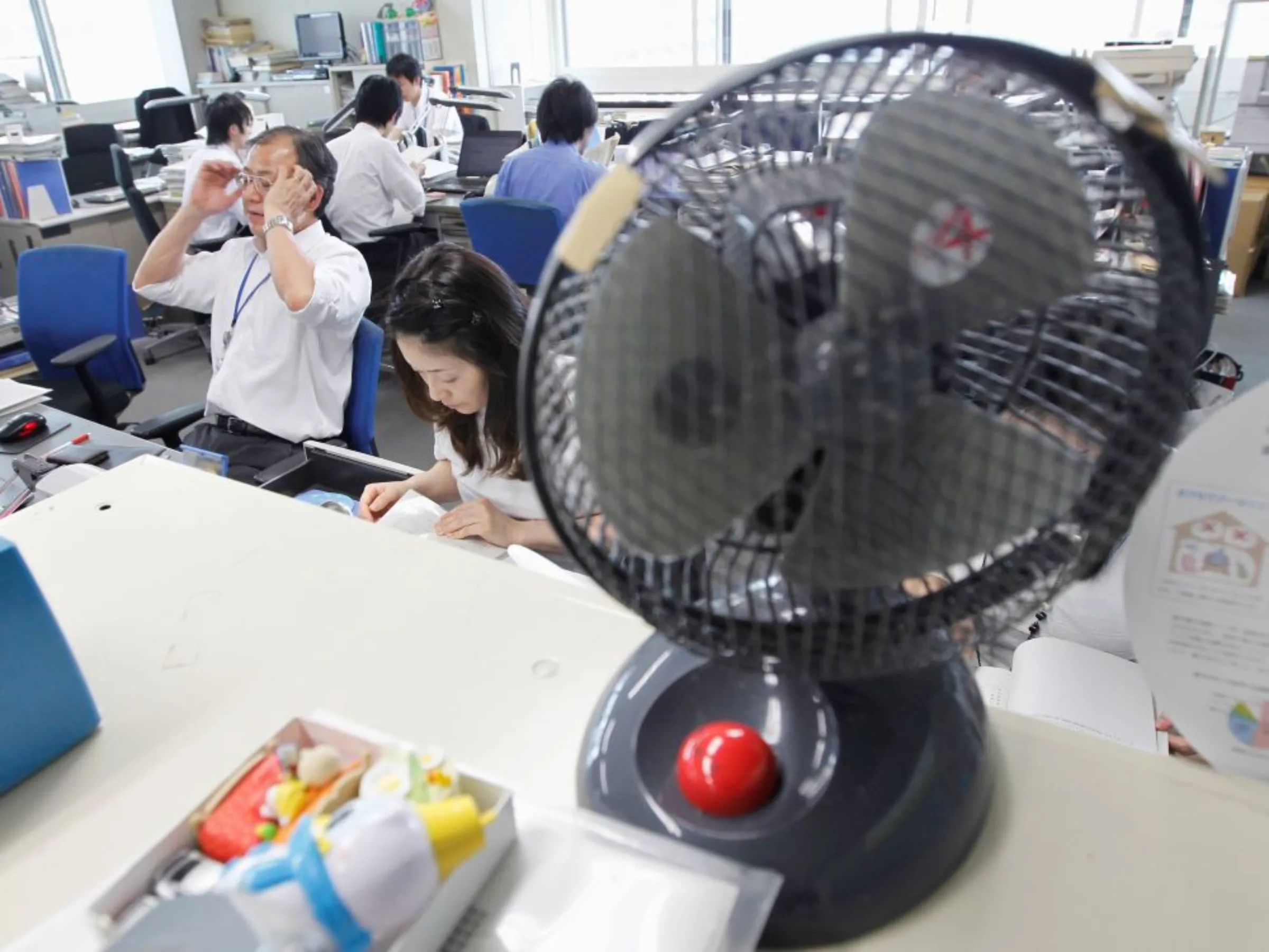 A portable electric fan is placed on a bookcase at the Environment Ministry in Tokyo May 1, 2012, on the kick-off day of Cool Biz which allow workers at government offices to take off their ties and roll up their sleeves as the air conditioners are turned down to save power and office temperatures go up.REUTERS/Kim Kyung-Hoon