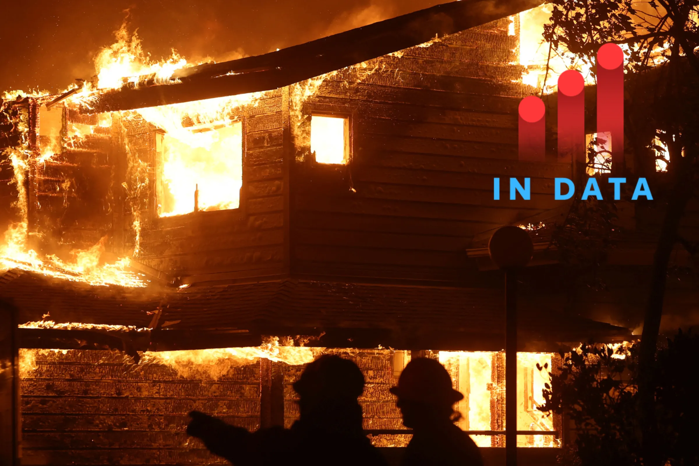 Two firefighters stand near a burning home during the Eaton Fire in Pasadena, California, U.S., January 7, 2025. REUTERS/Mario Anzuoni