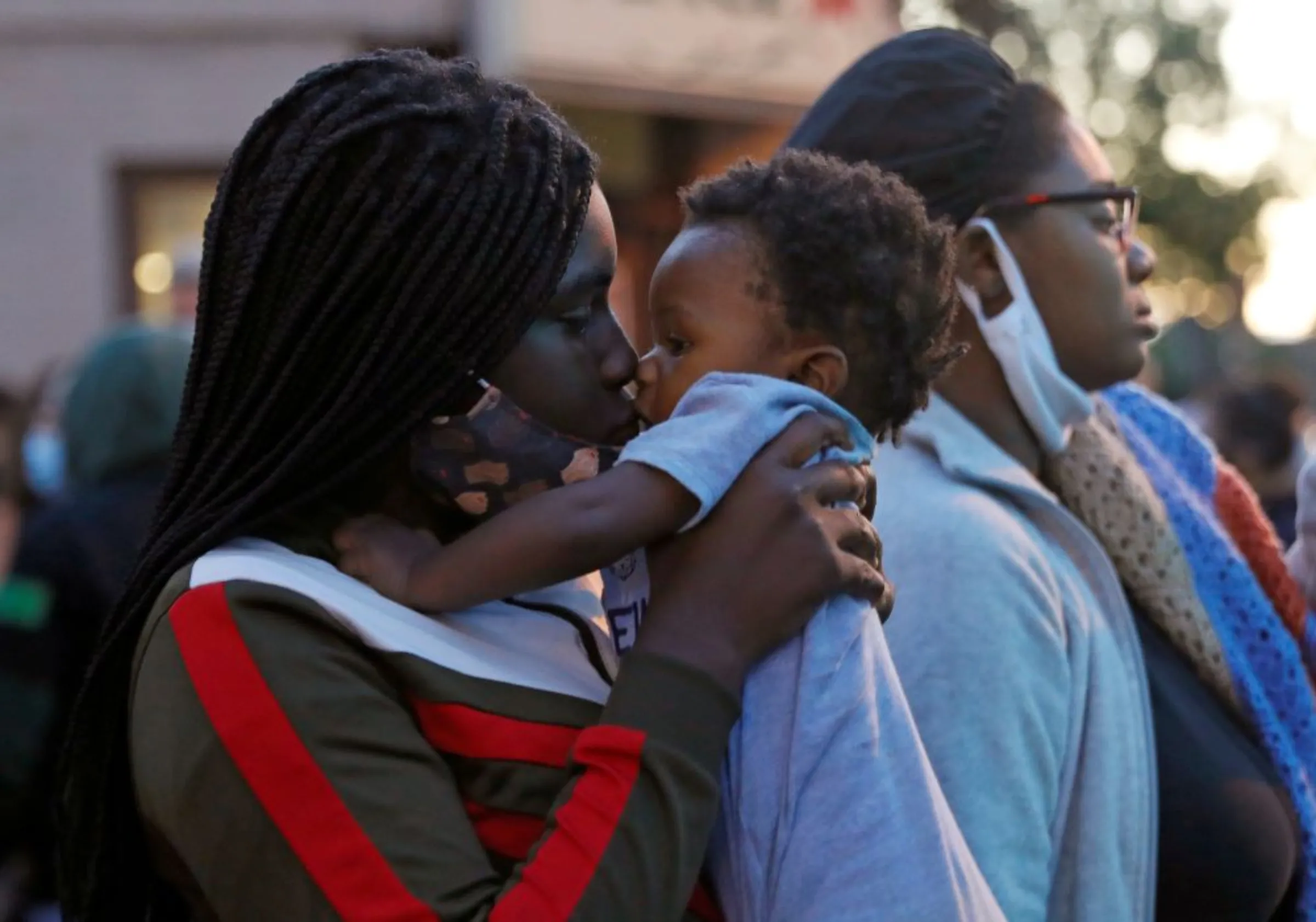 A woman kisses her child during a protest over the death of a Black man, in Rochester, New York, U.S.  September 6, 2020