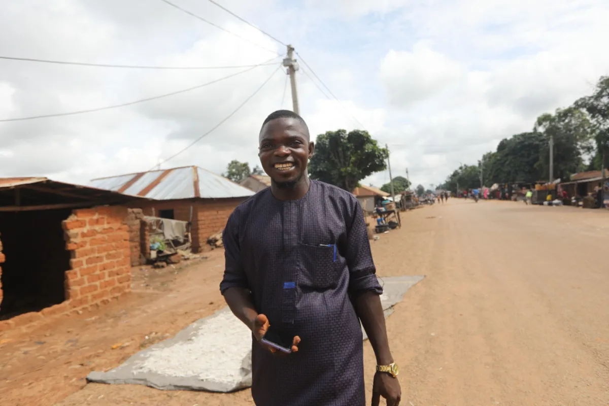 A Husk Power sales agent smiles on the street in Igbabo, Nasarawa, Nigeria, September 27, 2022. Thomson Reuters Foundation/Afolabi Sotunde