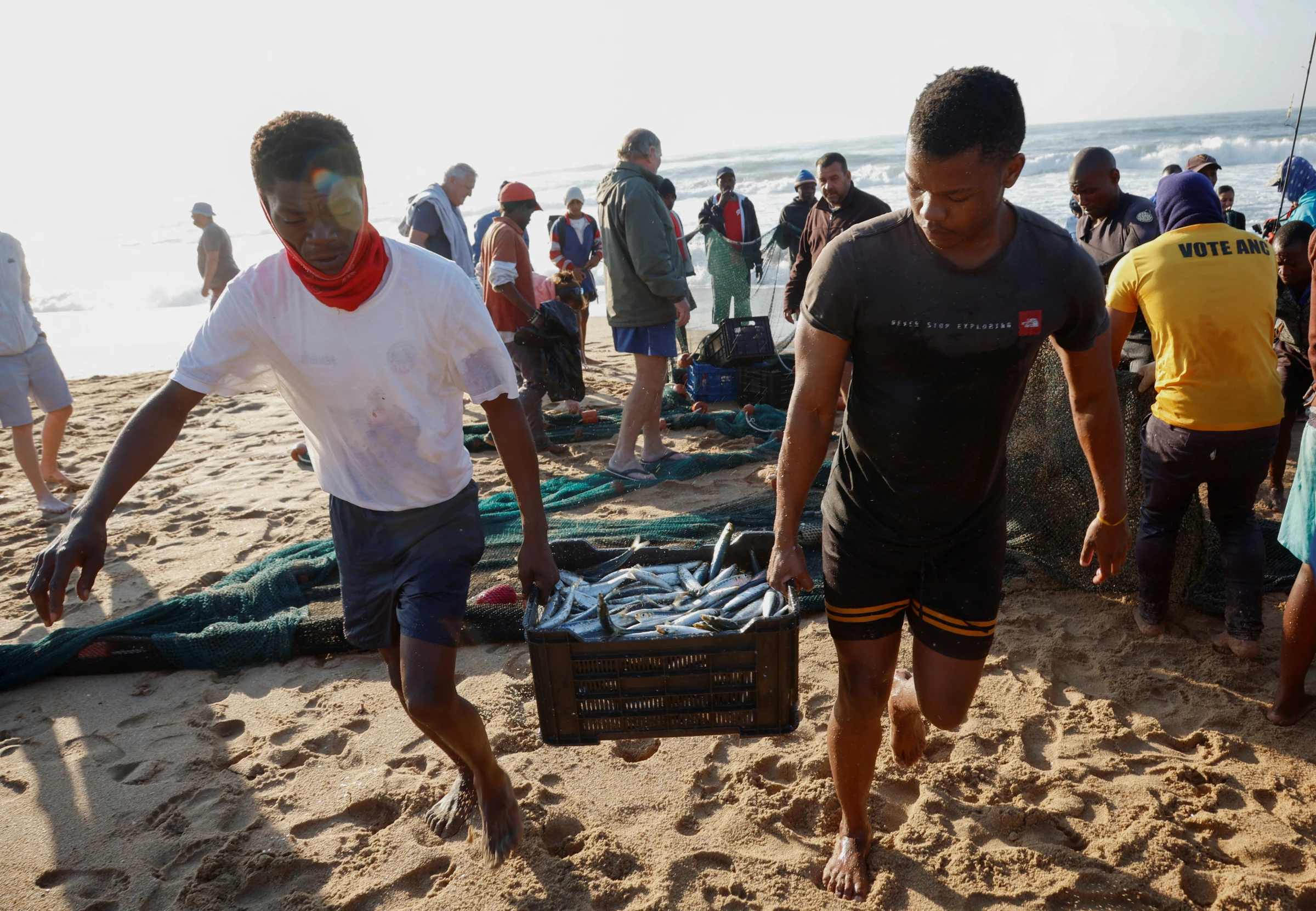 Fishermen carry a crate of fish during the sardine run in Scottburgh, South Africa, June 12, 2024. REUTERS/Rogan Ward