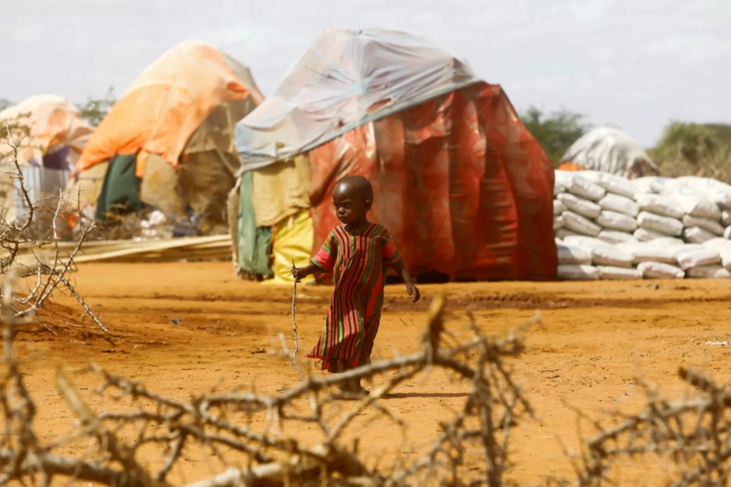 A child walks outside makeshift shelters at the Kaxareey camp for the internally displaced people after they fled from the severe droughts, in Dollow, Gedo Region, Somalia May 24, 2022. Picture taken May 24, 2022. REUTERS/Feisal Omar