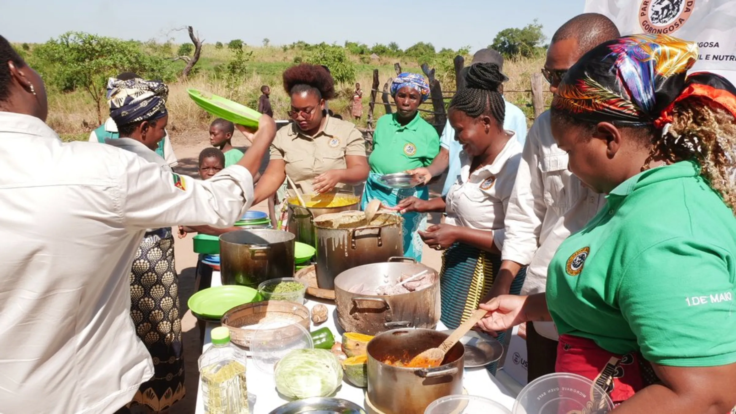 Members of Gorongosa National Park’s health and natural resource committee stand around a table of locally sourced food as part of a project to help improve nutrition in the buffer zone of the Mozambican park, May 24, 2022
