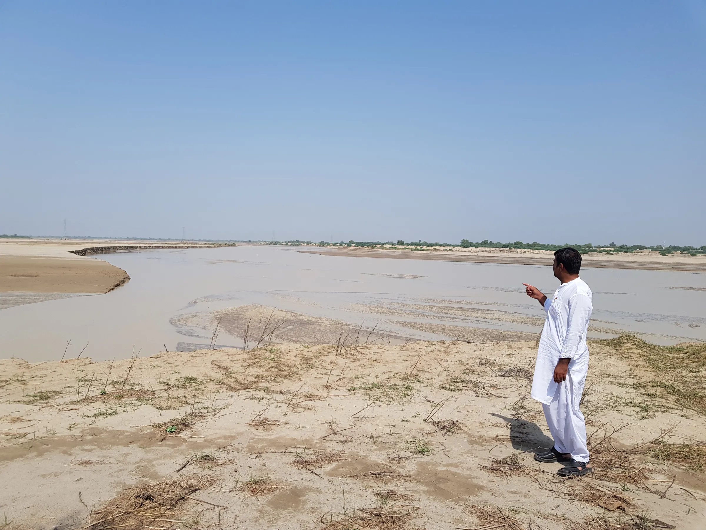 Omar Daraz, a cotton grower, points to the flood water that destroyed his crop in Hasanabad, Pakistan, September 28, 2022. Thomson Reuters Foundation/Waqar Mustafa