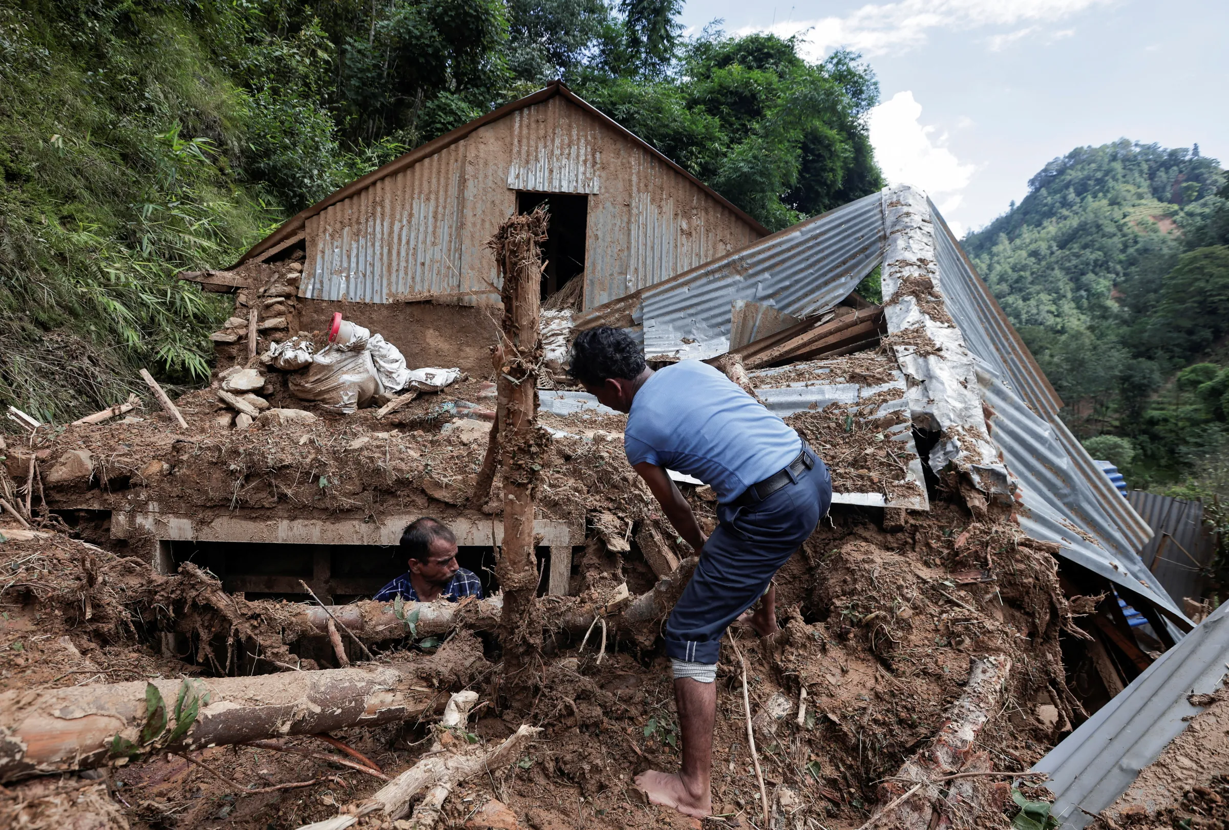 Villagers salvage goods from a collapsed house where two people died after the landslide following heavy rainfall, along the bank of Kalati River, in Bhumidanda village of Panauti municipality, in Kavre, Nepal October 1, 2024. REUTERS/Navesh Chitrakar