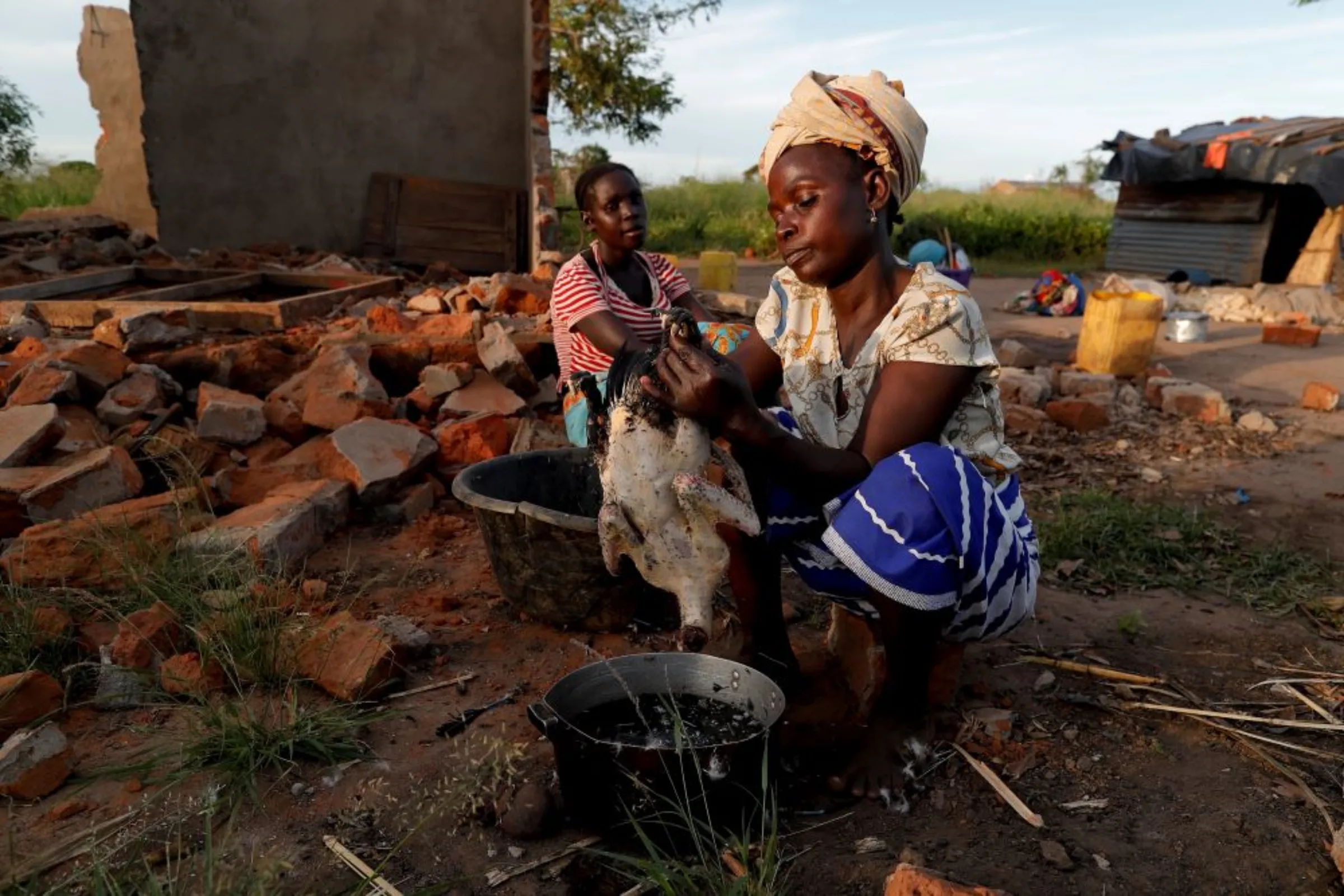 Women are preparing food beside their damaged house in the aftermath of Cyclone Idai, in the village of Cheia, which means 'Flood' in Portuguese, near Beira, Mozambique April 4, 2019