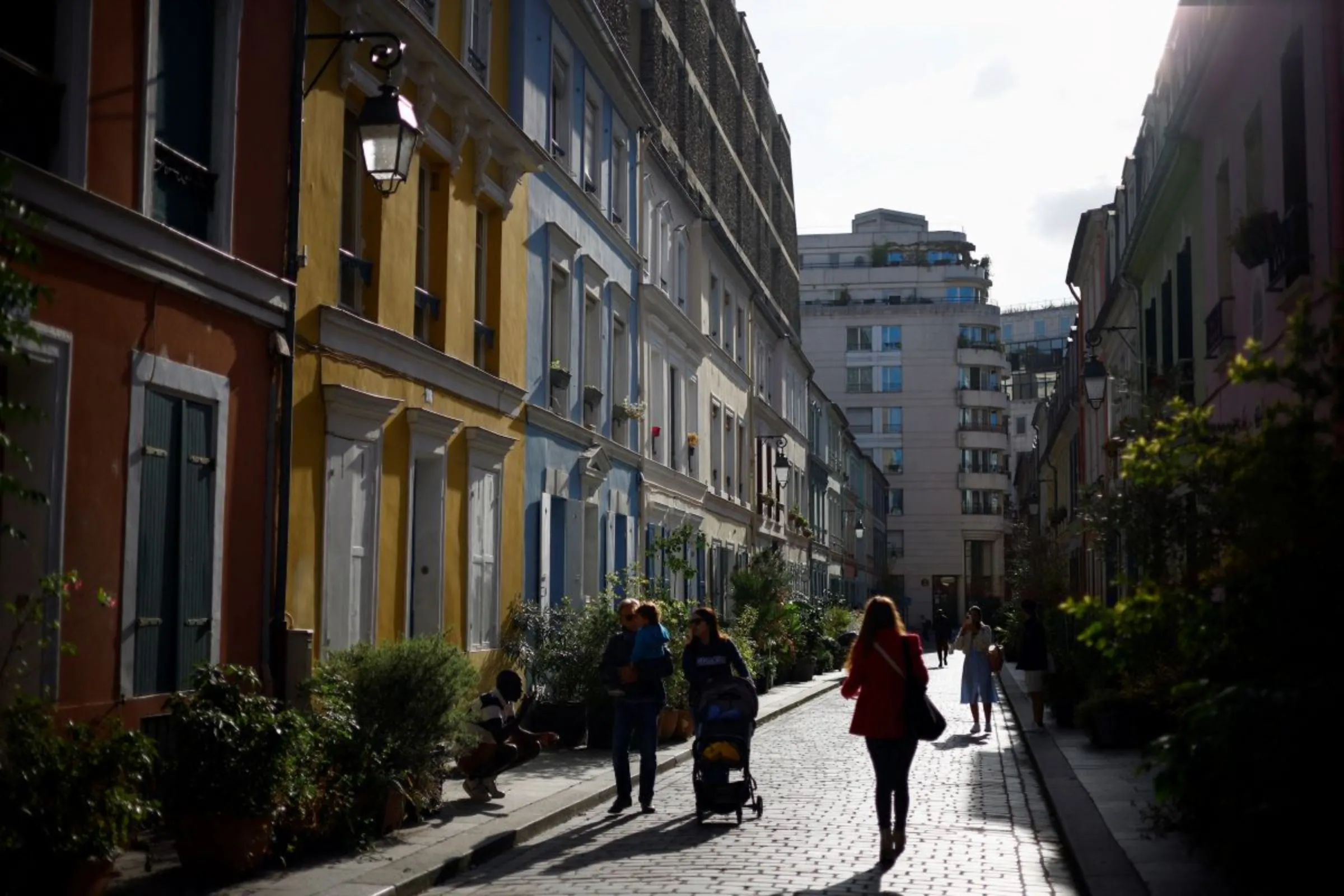 People walk in rue Cremieux, a street lined with colorful, terraced homes, in Paris, France October 4, 2023