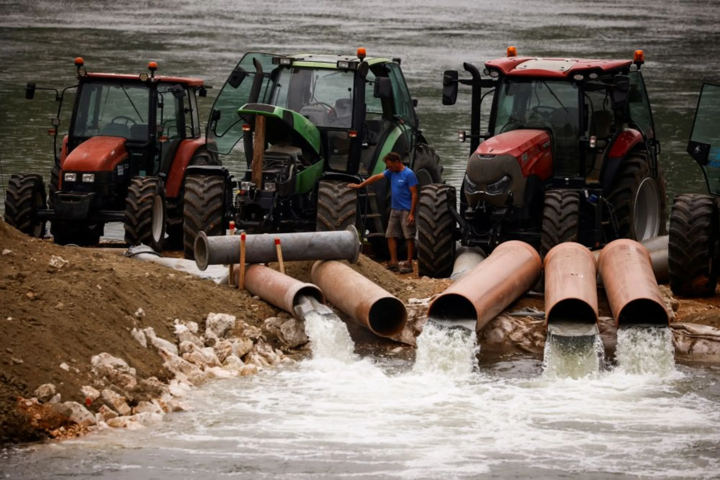 Tractors pump water from River Po to a channel as parts of Italy's longest river and largest reservoir of freshwater have dried up due to the worst drought in the last 70 years, in Isola Pescaroli, Italy June 22, 2022