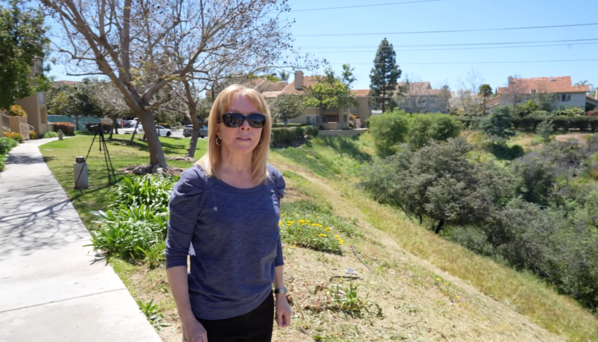 Paula Southwick, a resident of Canyon Park Villas, a southern California condo association that saw its insurance policy dropped as wildfire risks rise, stands outside some of the units, outside of San Diego, April 21, 2023