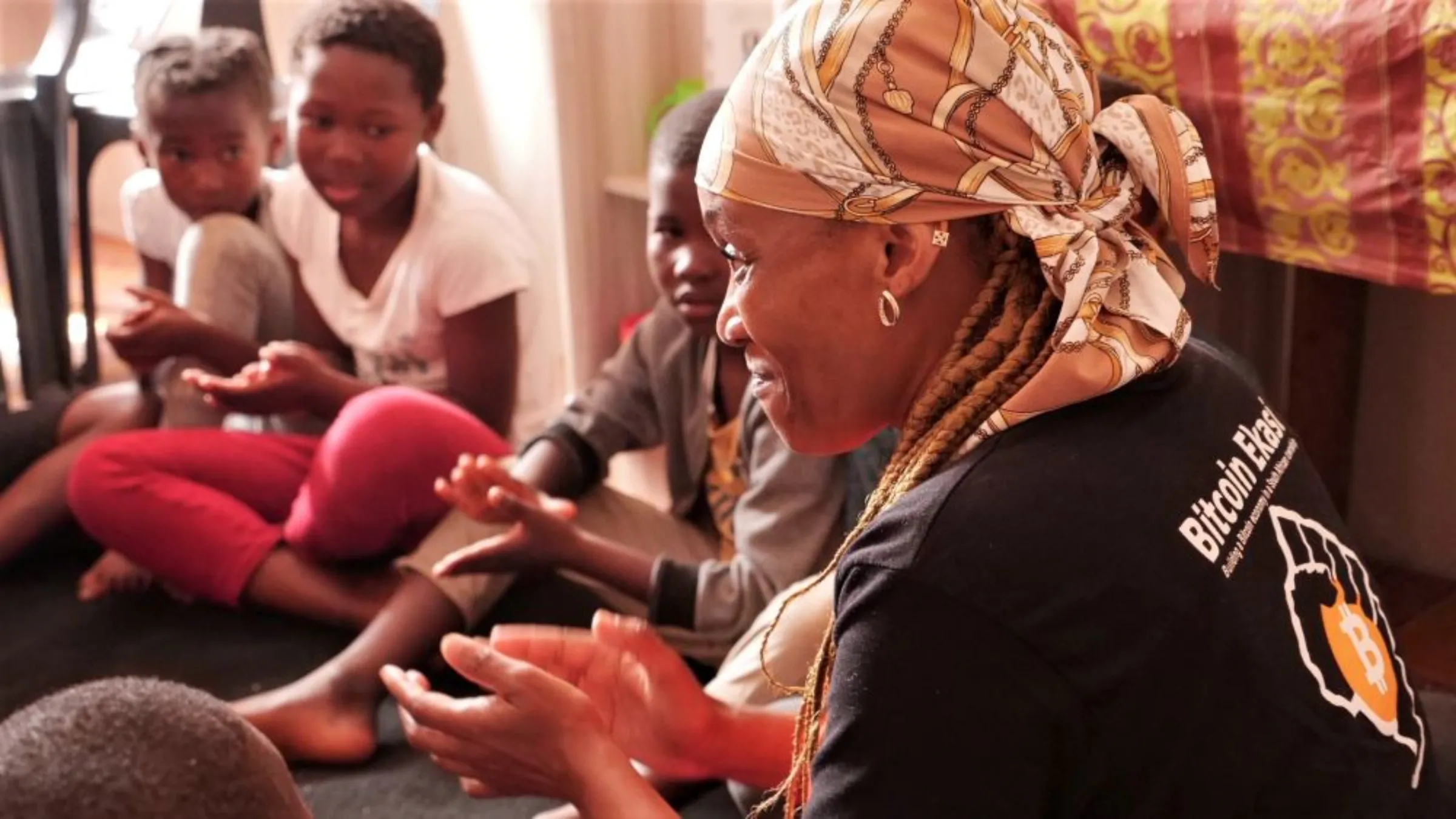 Nomsa Williams, the teacher at the bitcoin education centre, claps her hands while looking into the circle of students seated on the floor in Mossel Bay, South Africa, November 24, 2022