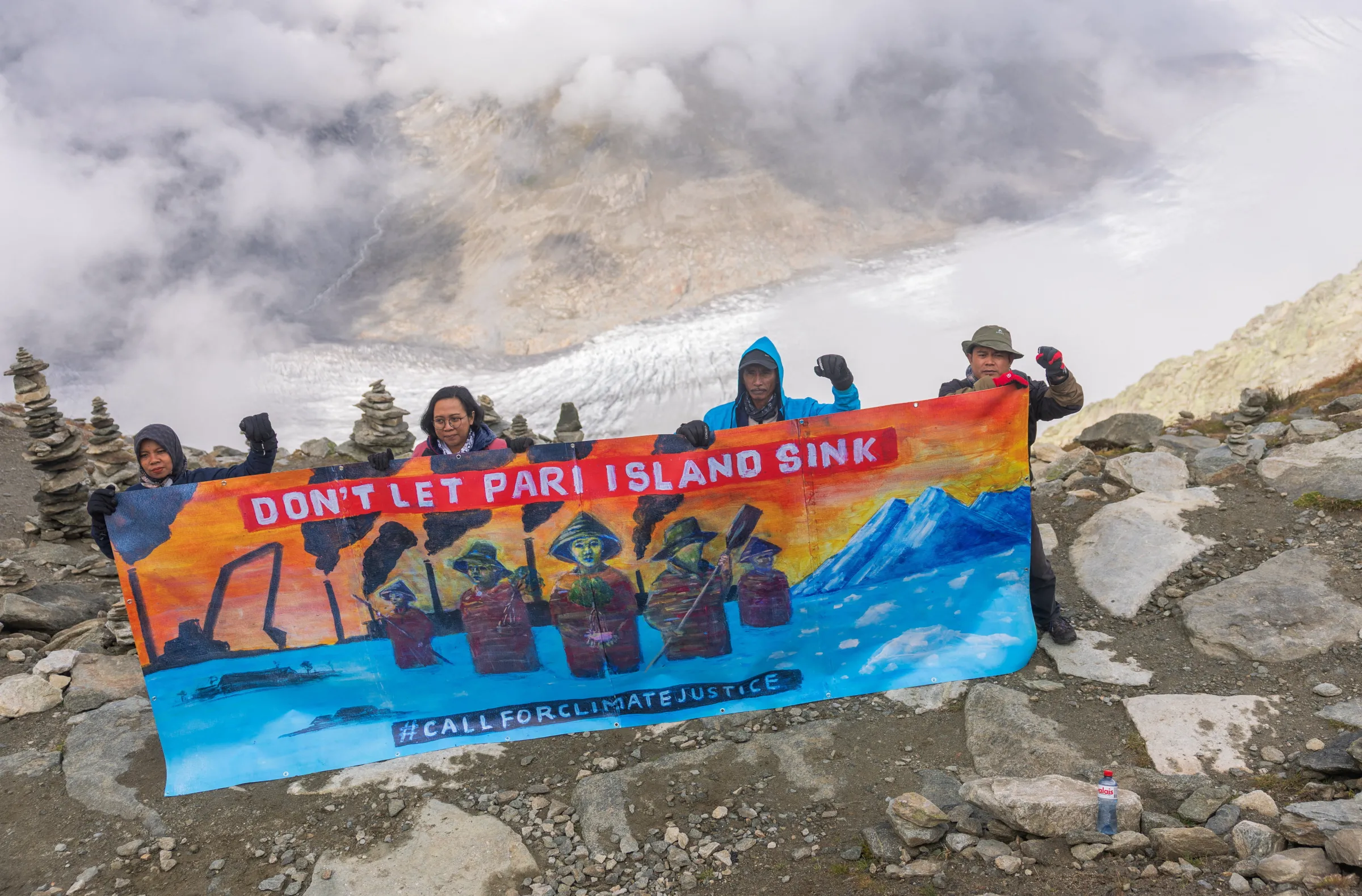 Residents of Indonesia's Pulau Pari Island and members of the Indonesian NGO Walhi hold a banner on Eggishorn mountain before a Swiss court's expected decision whether to accept a legal complaint filed by Indonesian residents against major cement manufacturer Holcim, which they say is doing 'too little' to cut carbon emissions, in Fiesch, Switzerland, August 30, 2025. REUTERS/Denis Balibouse