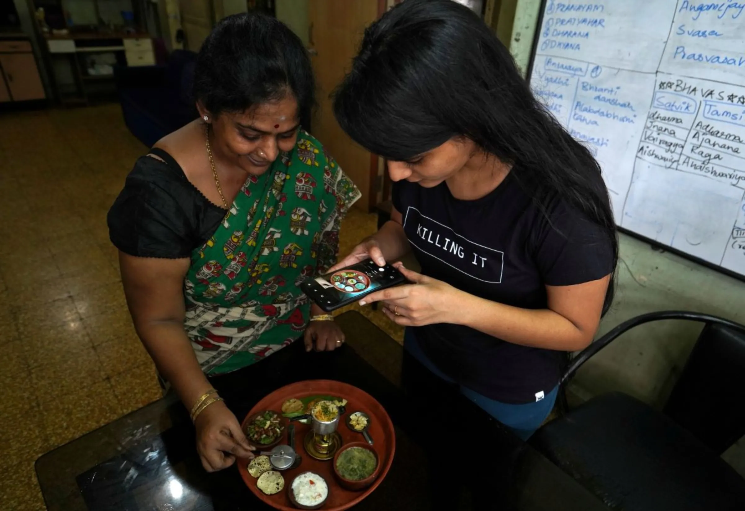 A woman who used to post over a dozen videos on video-sharing app TikTok, makes a video on her miniature cooking with her daughter that she will upload on an Indian app, after India banned dozens of Chinese apps including TikTok following a border clash between the two nations, inside their house in Mumbai, India, July 1, 2020. REUTERS/Hemanshi Kamani