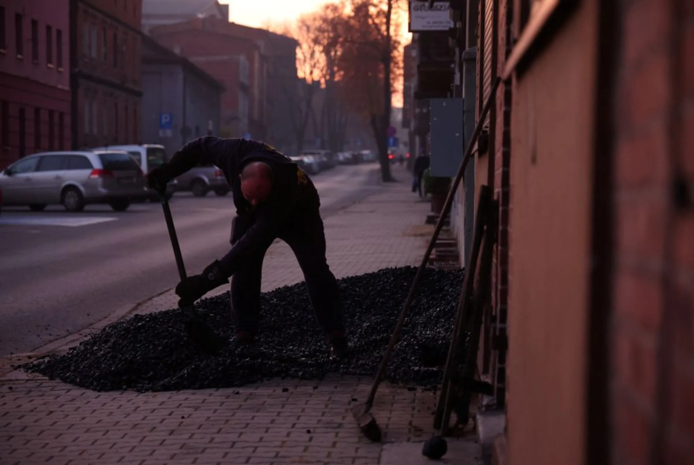 A man shovels coal into the basement of a house in Piekary Slaskie, Poland October 27, 2022. REUTERS/Kacper Pempel