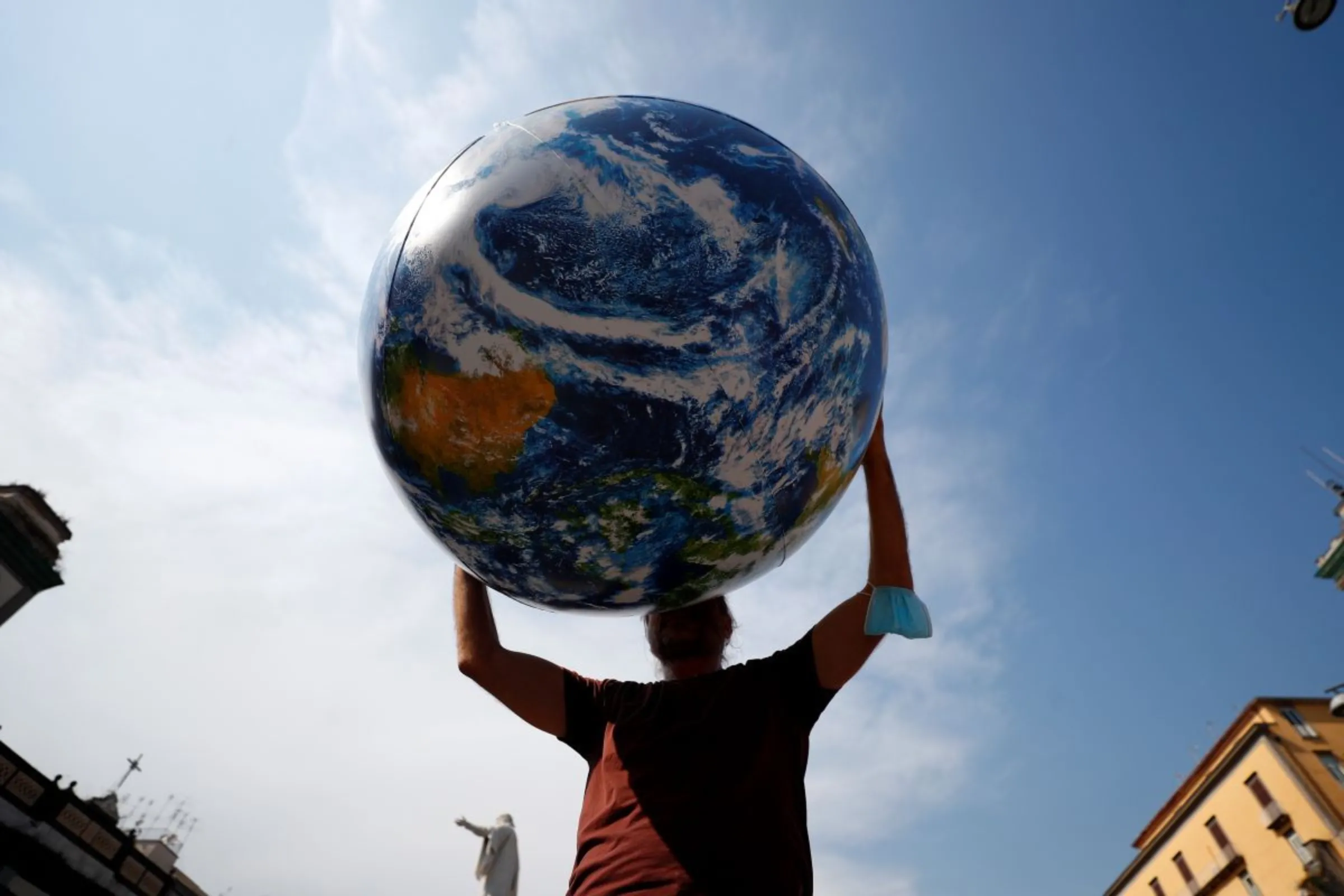 A person holds inflatable Earth as climate activists stage a protest demanding more action whilst G20 climate and environment ministers hold a meeting in Naples, Italy, July 22, 2021