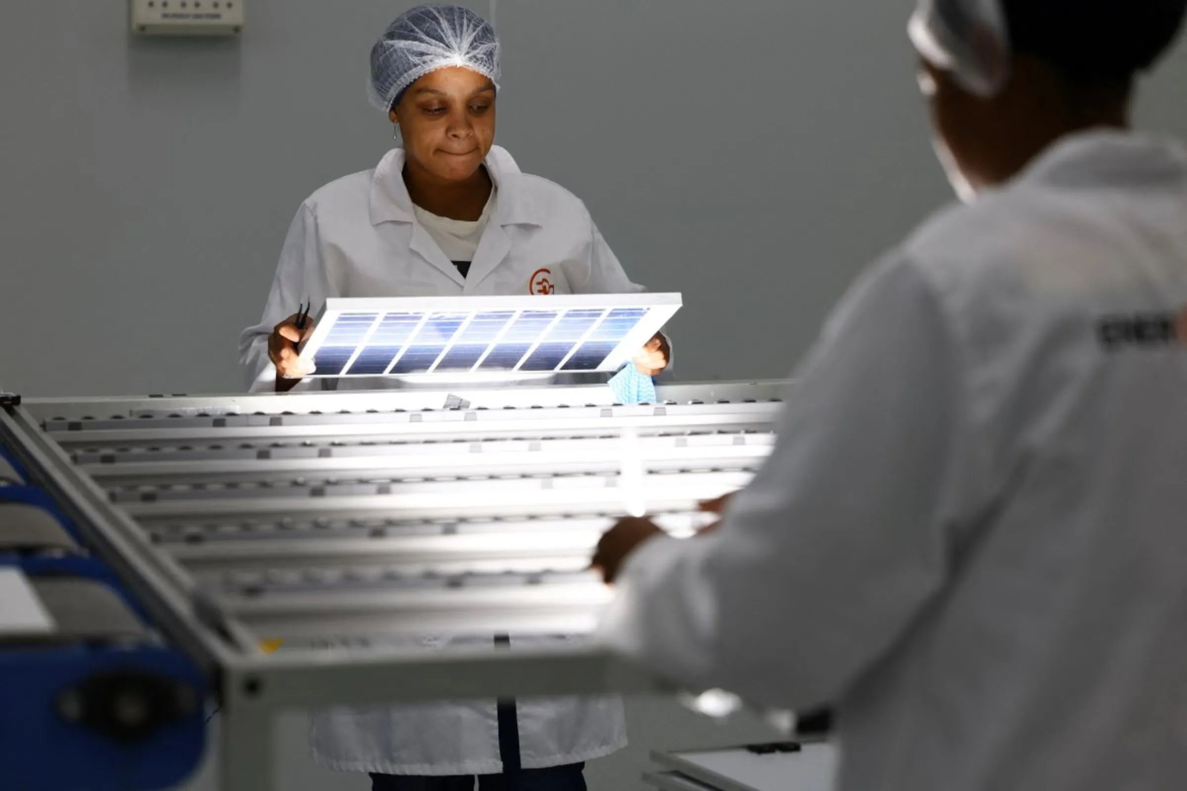 A woman looks at a solar panel, at a factory called Ener-G-Africa, where high-quality solar panels made by an all-women team are produced, in Cape Town, South Africa February 9, 2023