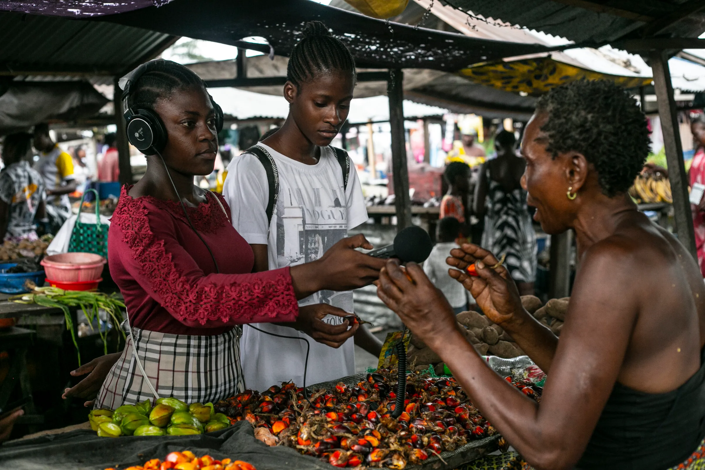 Young reporters from the Children’s Radio Foundation interview a market vendor at the Kapela Market in Kinshasa, The Democratic Republic of Congo, March 15, 2021.  Ley Uwera/Handout via Thomson Reuters Foundation
