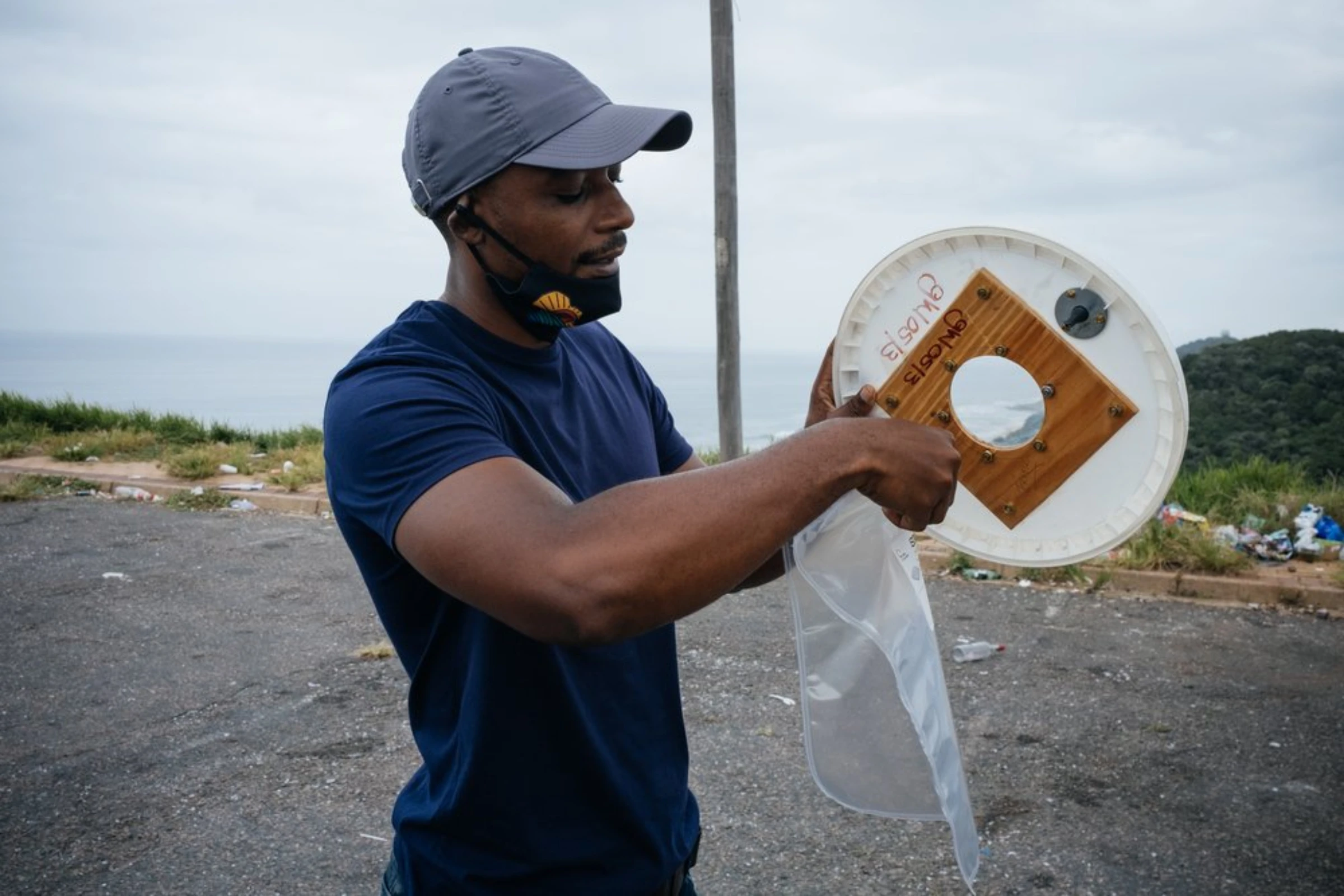 South Durban Community Environmental Alliance (SDCEA) air quality and youth development officer Bongani Mthembu gets ready to test the air quality near the SAPREF oil refinery in south Durban, South Africa, April 1, 2021