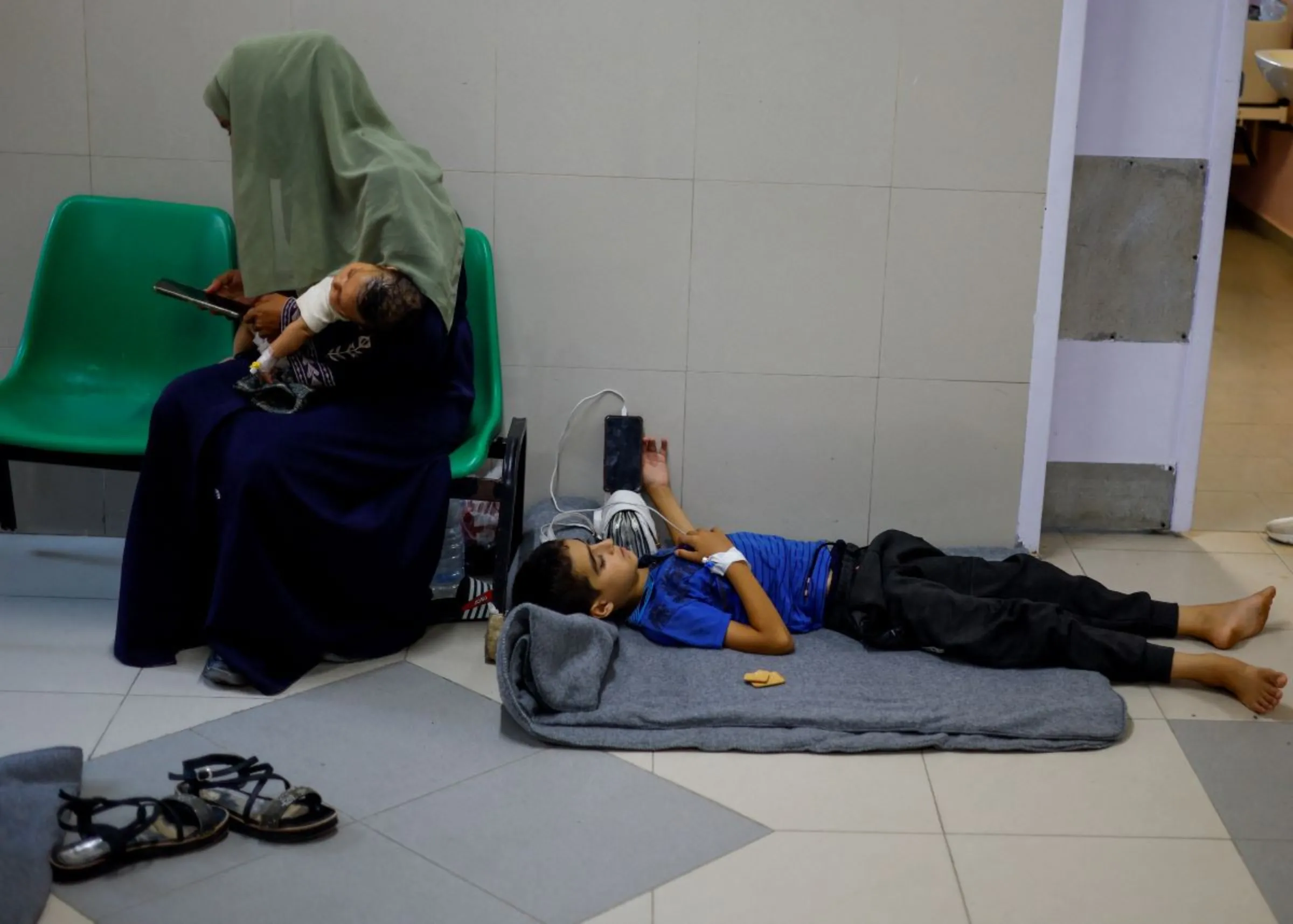 A Palestinian boy lays on the floor as patients are treated in the corridors at Nasser hospital, in Khan Younis, in the southern Gaza Strip, July 8, 2024. REUTERS/Mohammed Salem