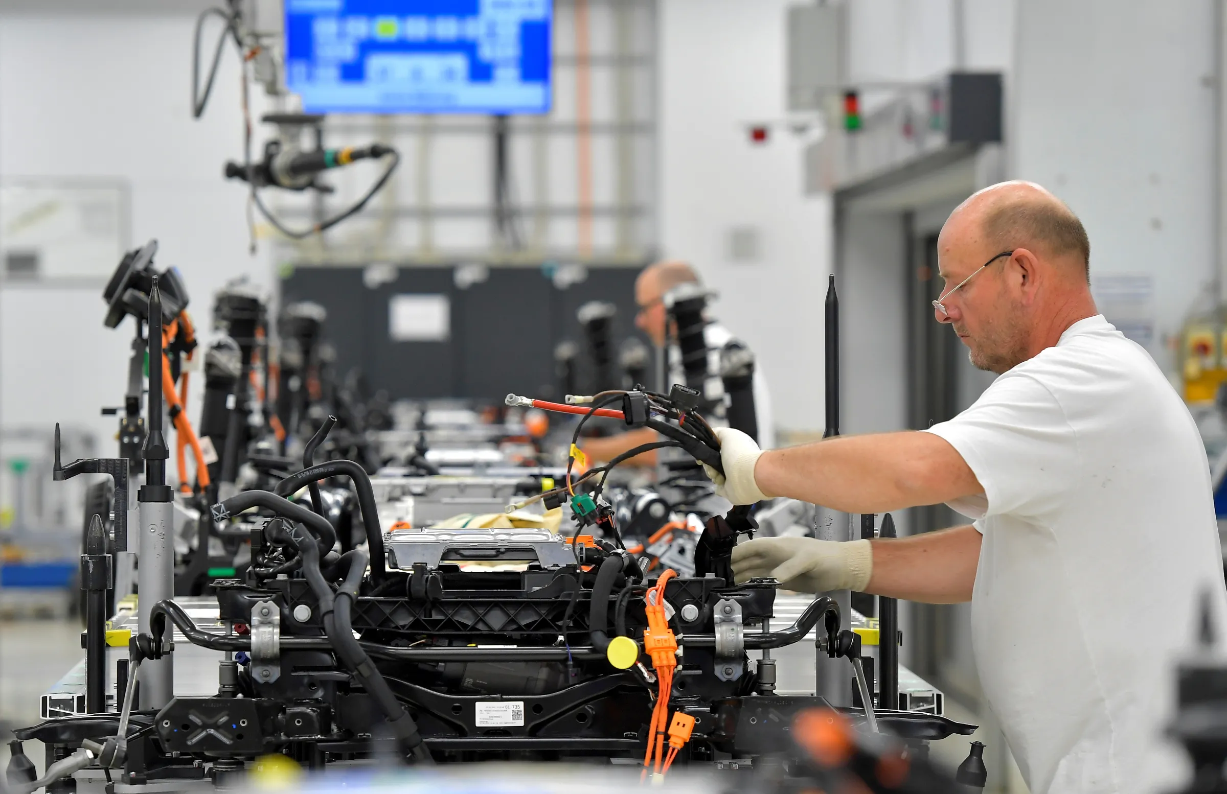 A man works with machinery at a car factory