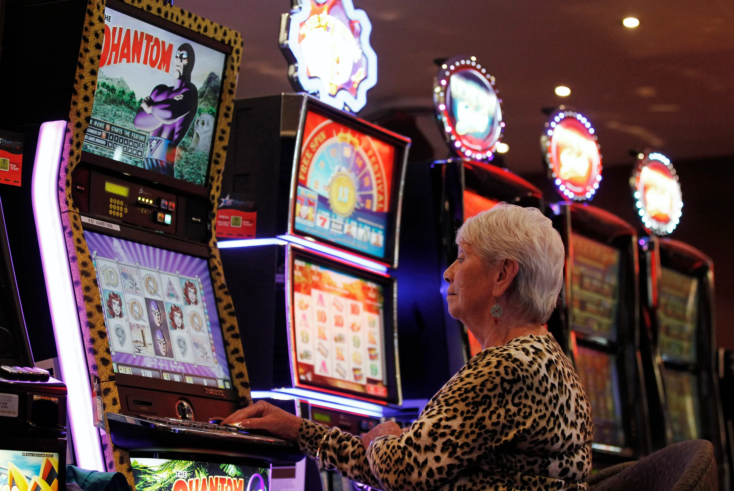 A woman plays a slot machine at club in Central Sydney November 23, 2011. REUTERS/Daniel Munoz