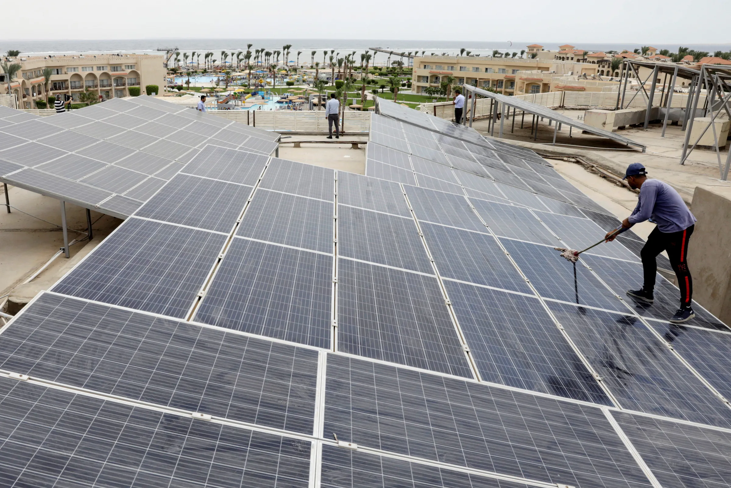 A worker cleans solar cells on a rooftop of a hotel in the resort town of Sharm el-Sheikh, the first to operate a solar-powered plant in a bid to turn to clean energy as the city prepares to host the upcoming COP27 summit in November, in Sharm el-Sheikh, Egypt, June 4, 2022. REUTERS/Mohamed Abd El Ghany