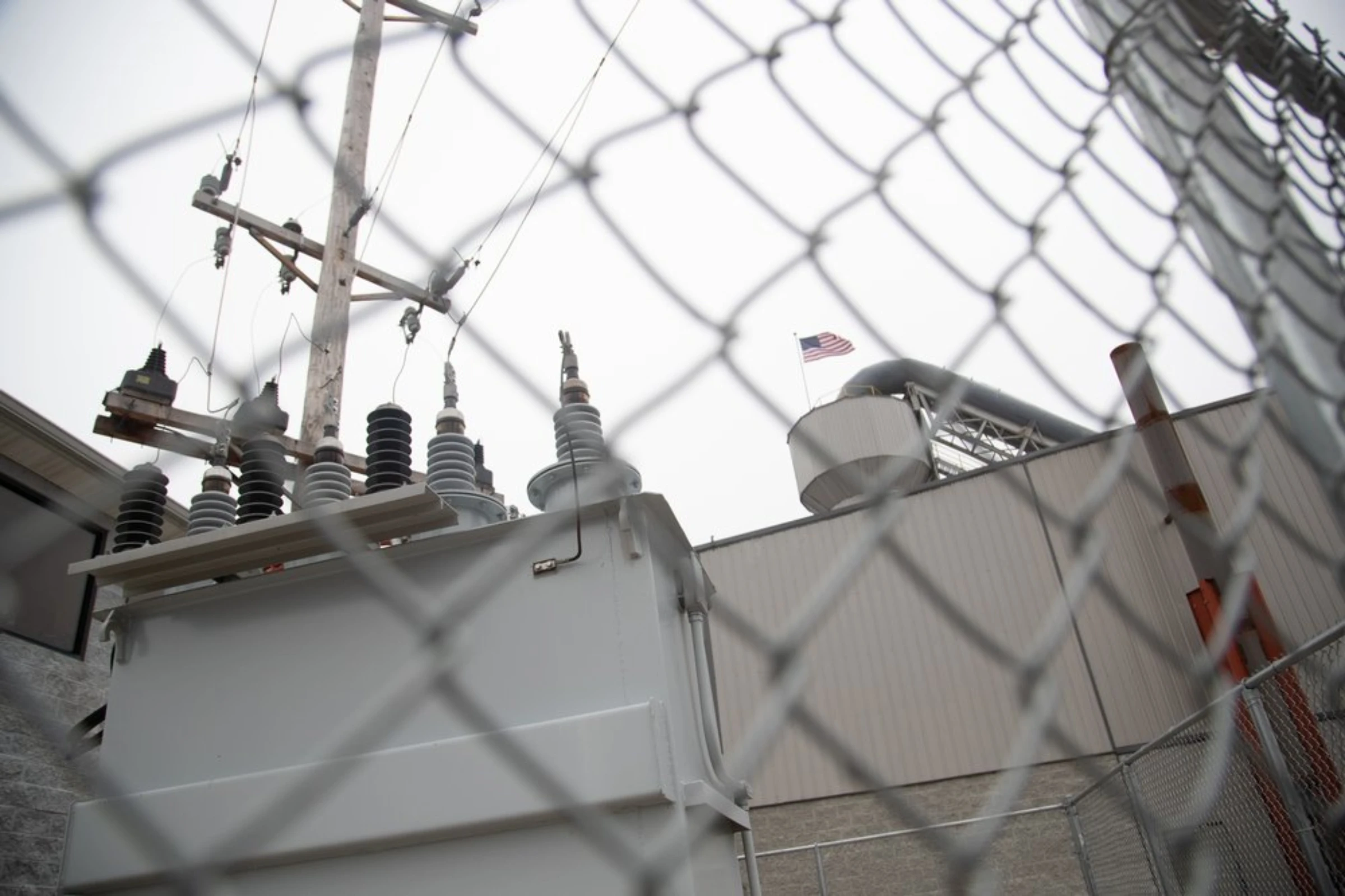 A U.S. flag flies next to power grids in Inez, Kentucky, January 25, 2022. Thomson Reuters Foundation/Amira Karaoud