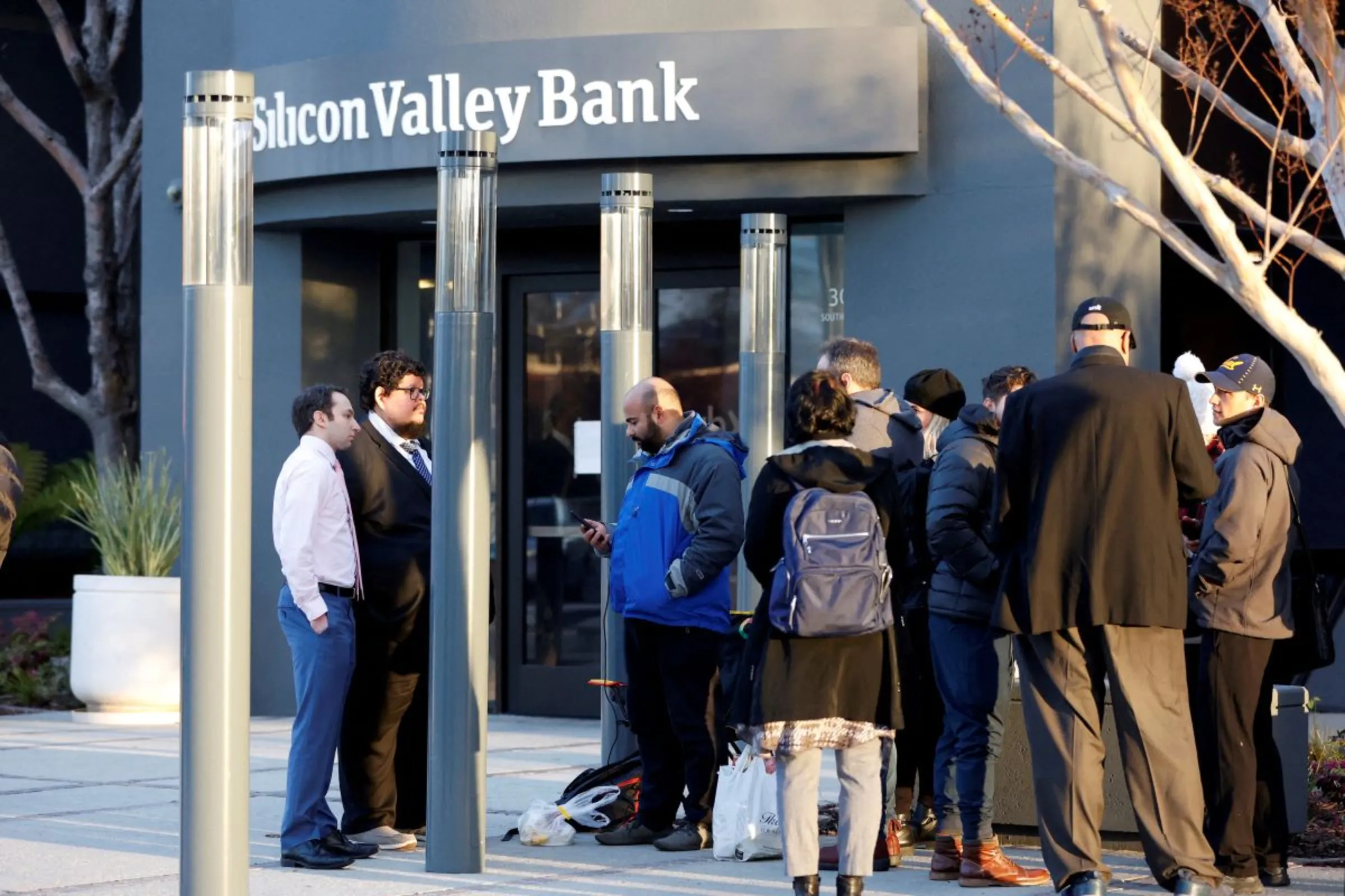 FDIC representatives speak with customers outside of the Silicon Valley Bank headquarters in Santa Clara, California, U.S. March 13, 2023. REUTERS/Brittany Hosea-Small