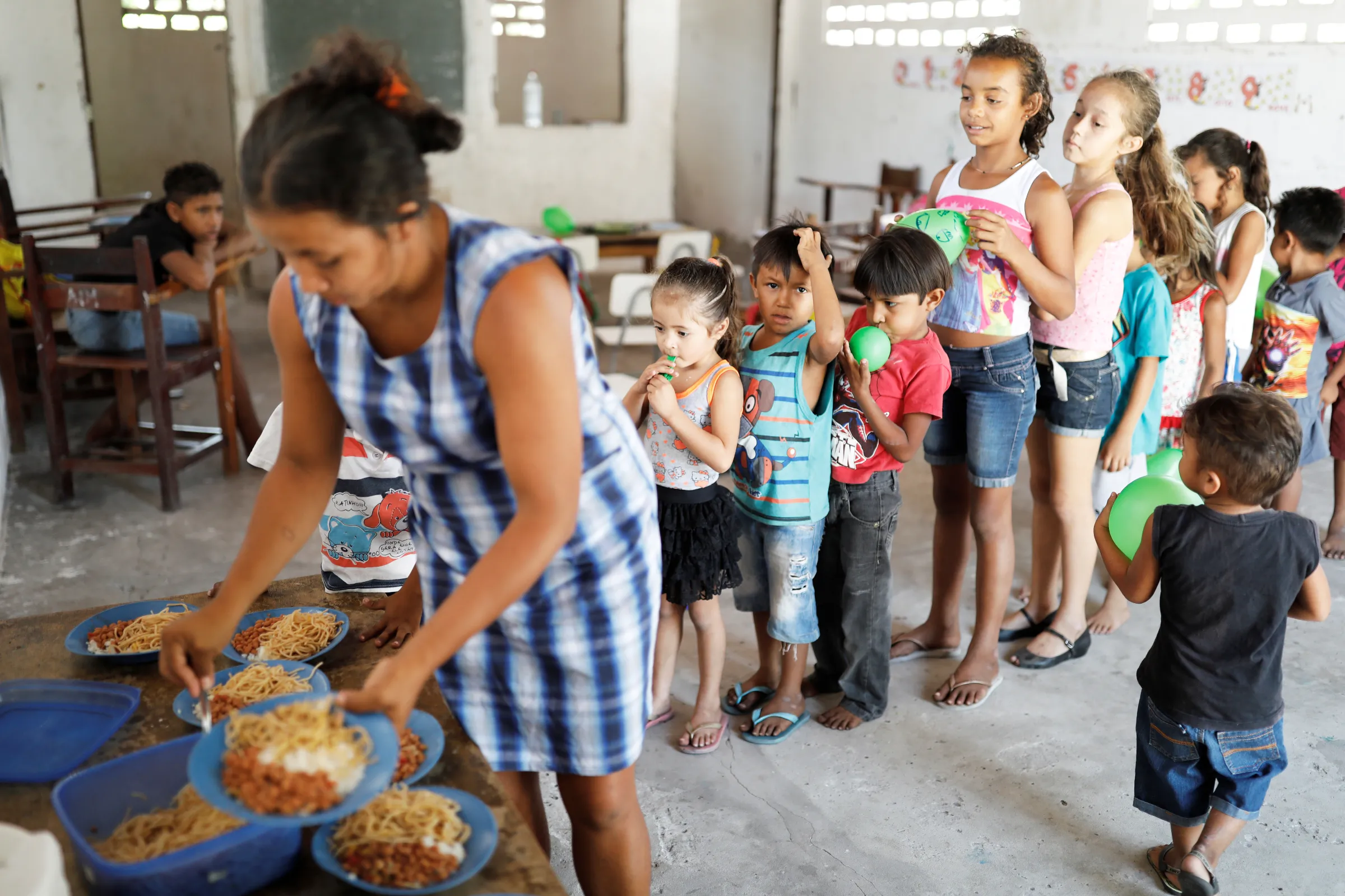 A woman serves food to pupils during class recess at Sao Jose school in Morro Do Veridiano, Belagua Municipality, Maranhao state, Brazil, October 11, 2018. REUTERS/Nacho Doce